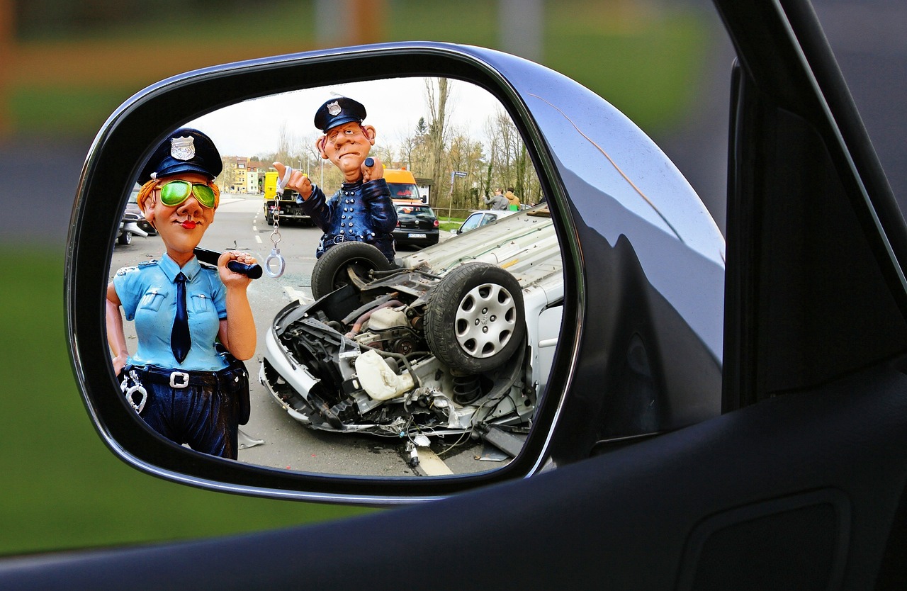 Karambol na S2: leżący na boku samochód w lusterku wstecznym i dwie figurki policjantów.