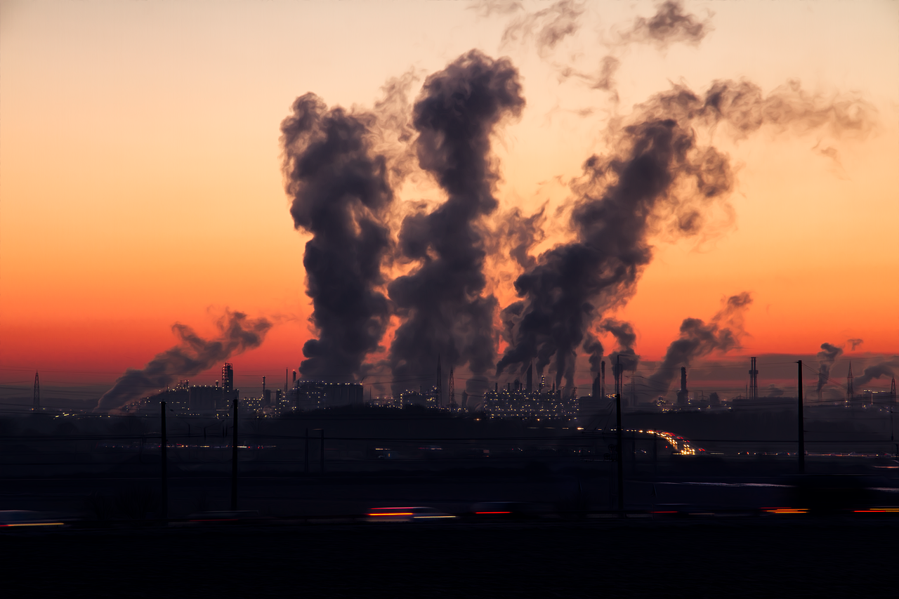 Smog z fabryk podczas zachodu słońca, symbol problemów zanieczyszczenia.