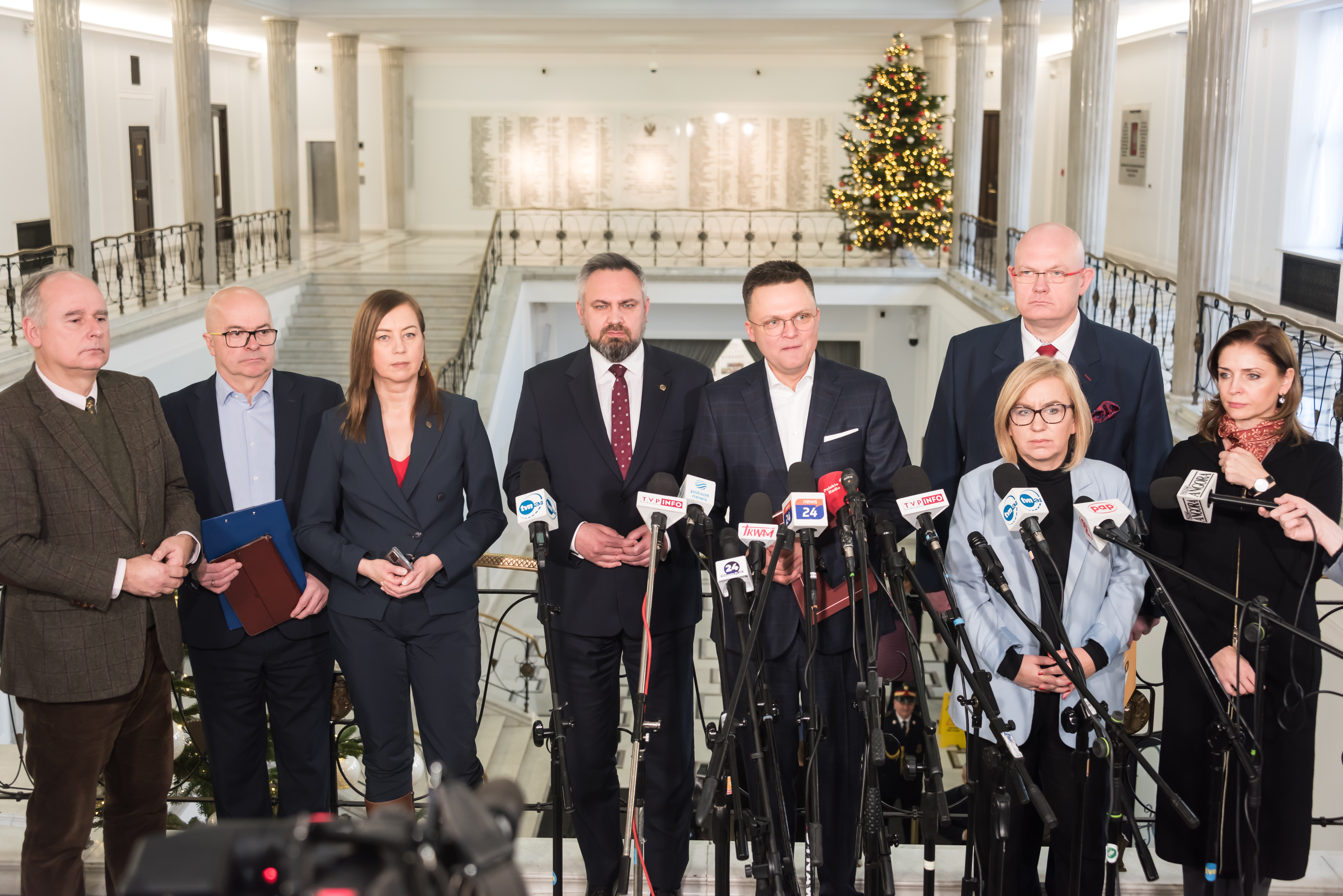 Szymon Hołownia z grupą polityków podczas konferencji prasowej, podkreśla dumę z kobiecej reprezentacji w rządzie.