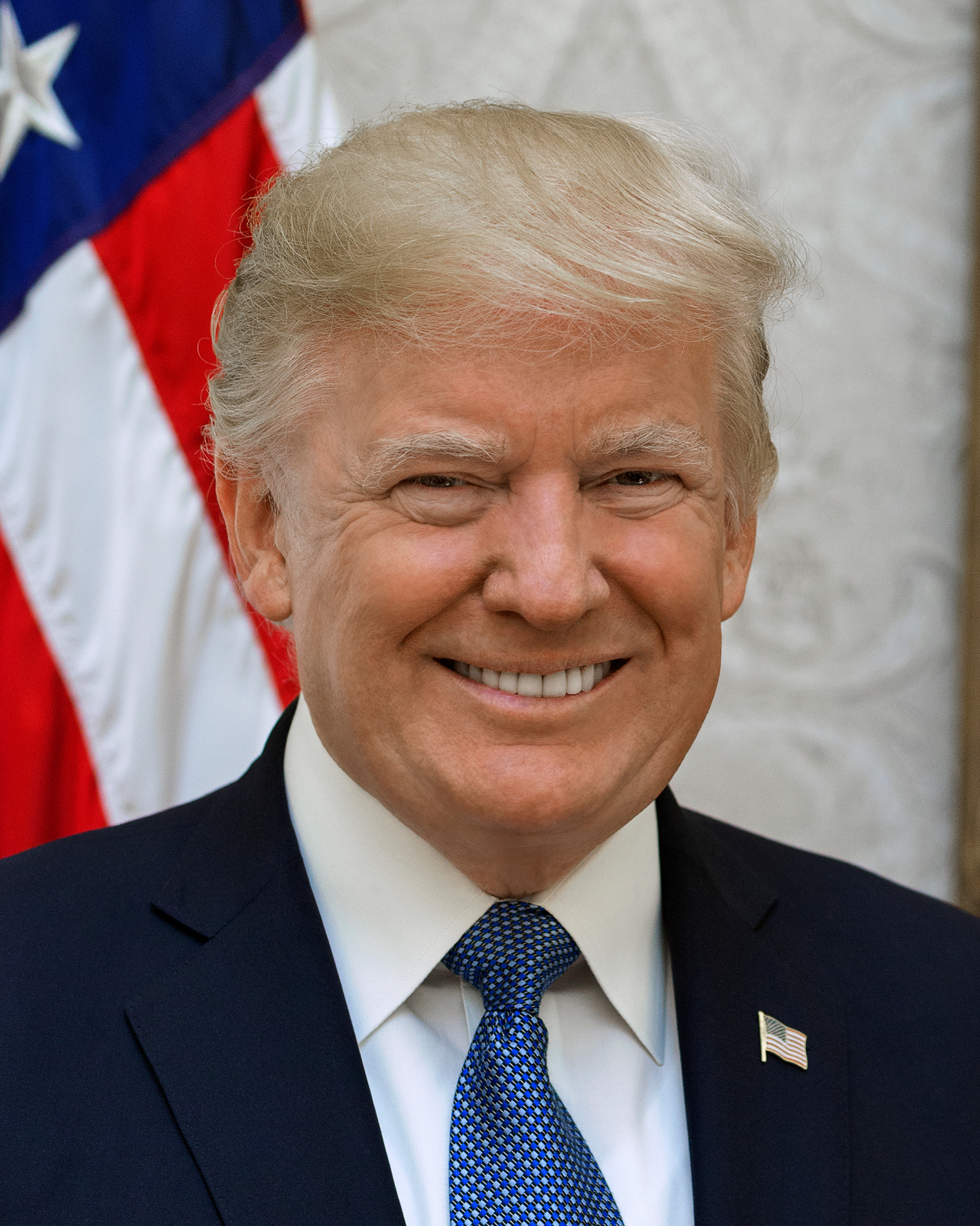 Donald Trump w garniturze z amerykańską flagą, omawiający cła wpływające na małe firmy.