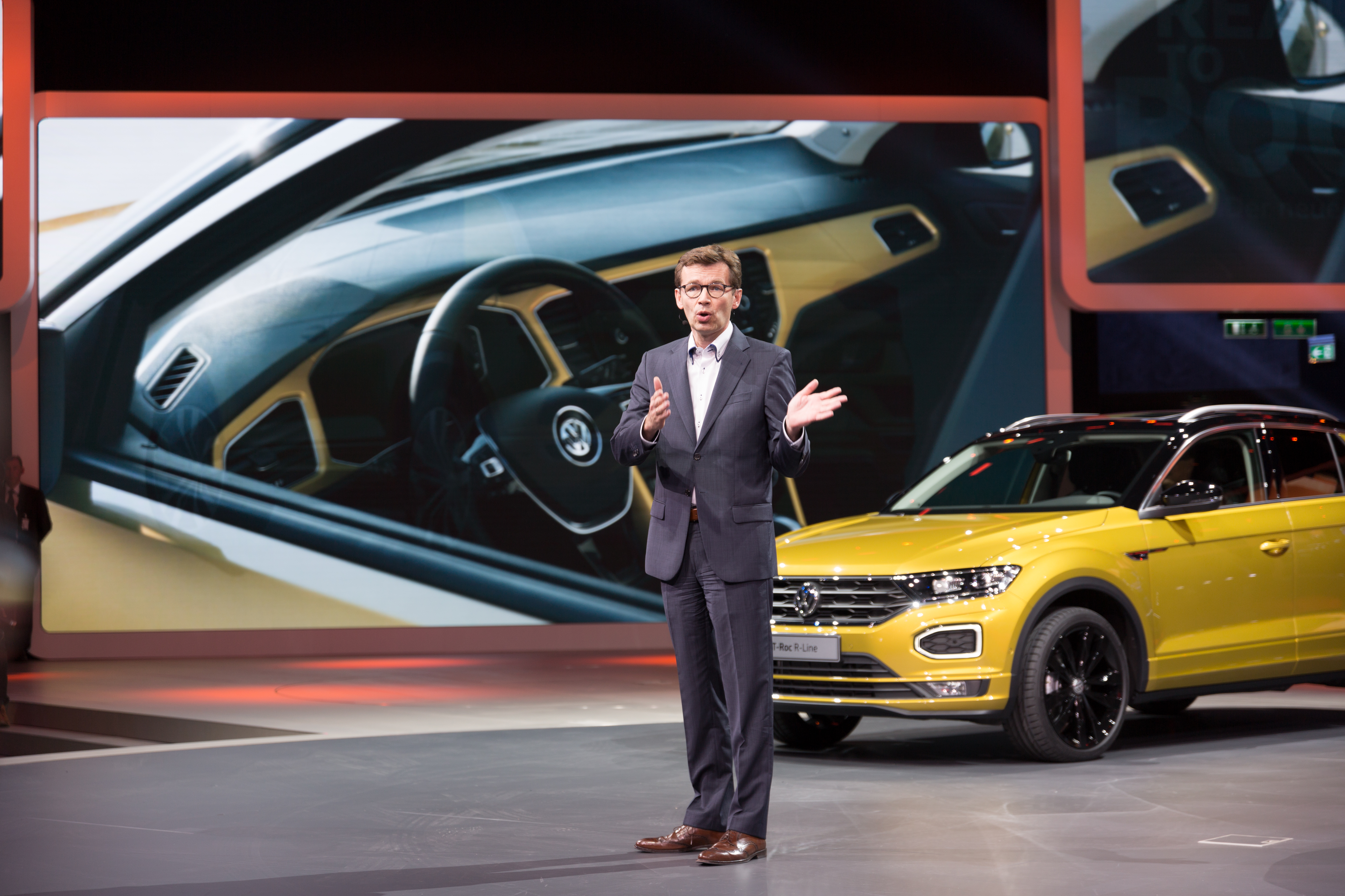 Prezentacja nowego Volkswagena T-Roc R-Line z żółtym nadwoziem i nowoczesnym wnętrzem.