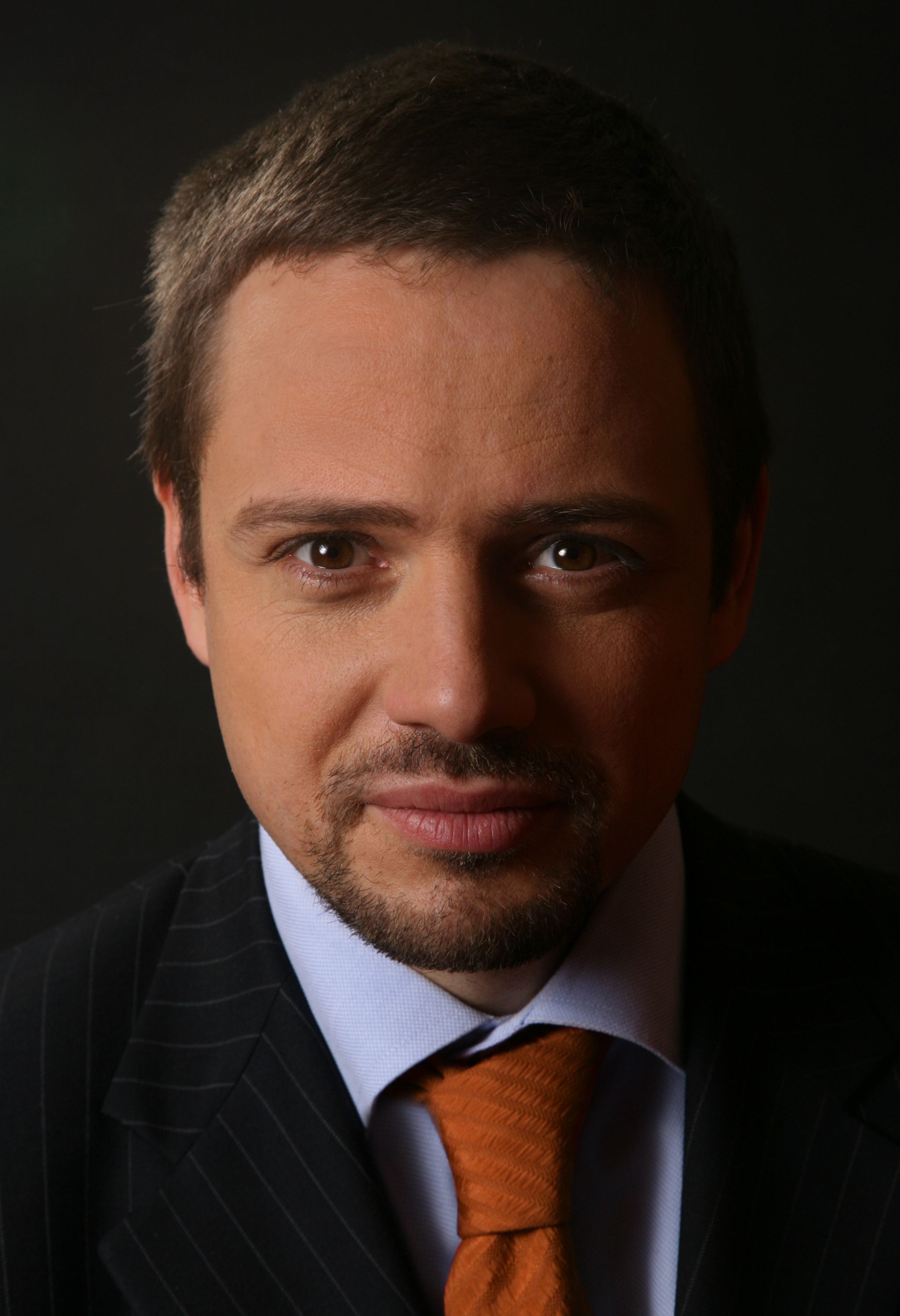 Portret Rafała P., oskarżonego o atak w metrze, ubranego w garnitur i krawat.