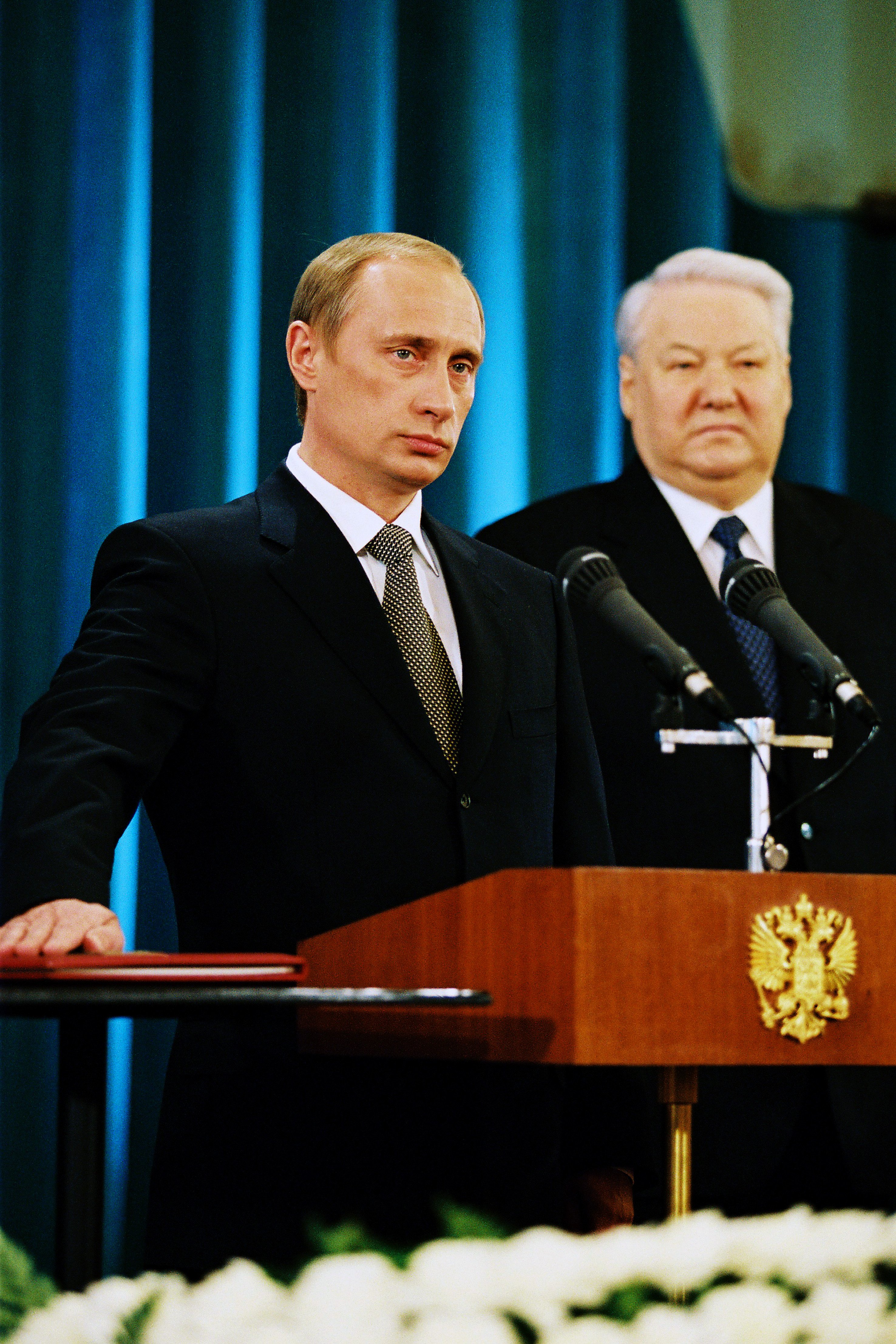 Vladimir Putin przemawia przy mównicy, obok stoi Boris Jelcyn. Kluczowy błąd Putina na Ukrainie.