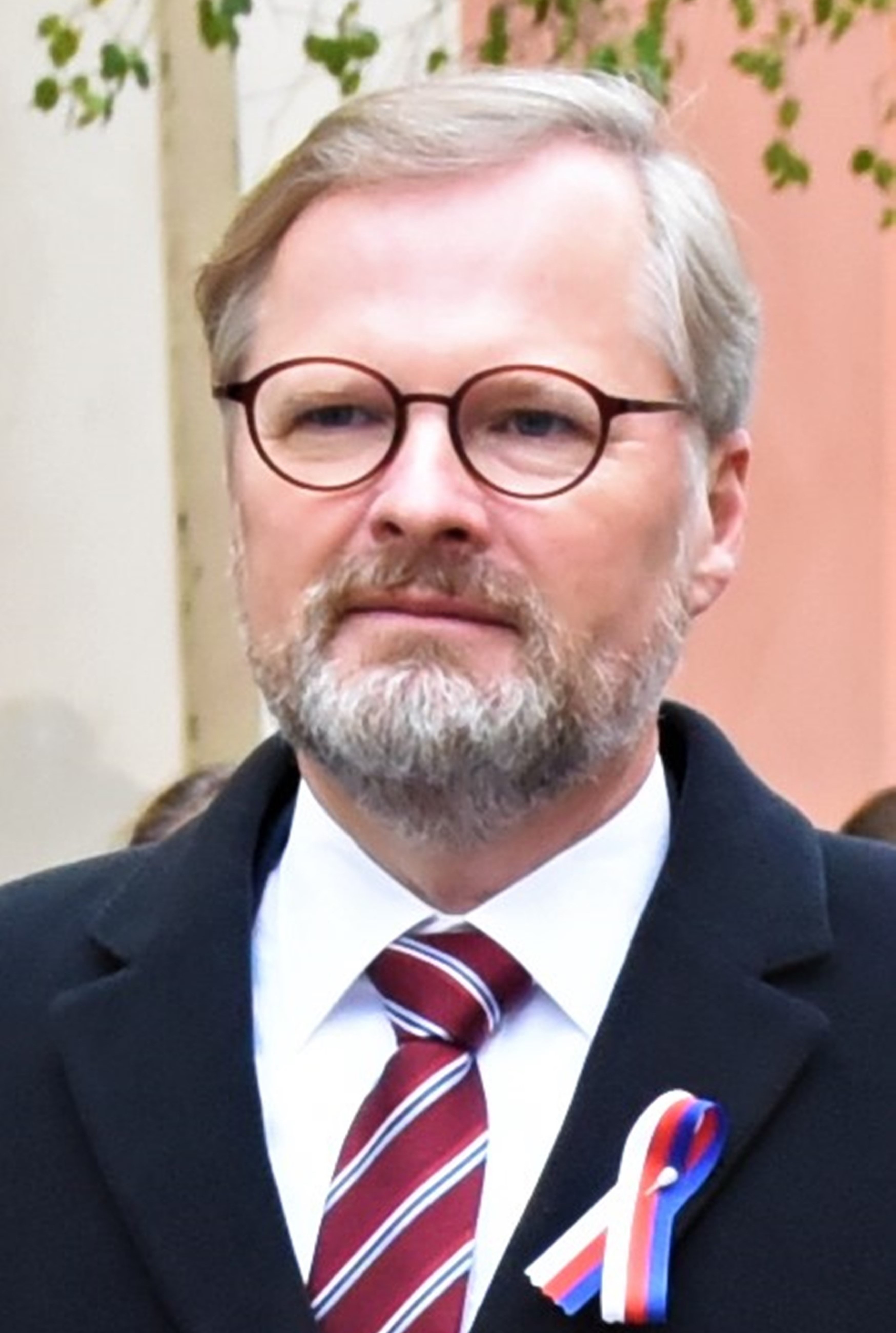 Premier Czech Petr Fiala w garniturze i krawacie, ostrzega przed rosyjską ekspansją.