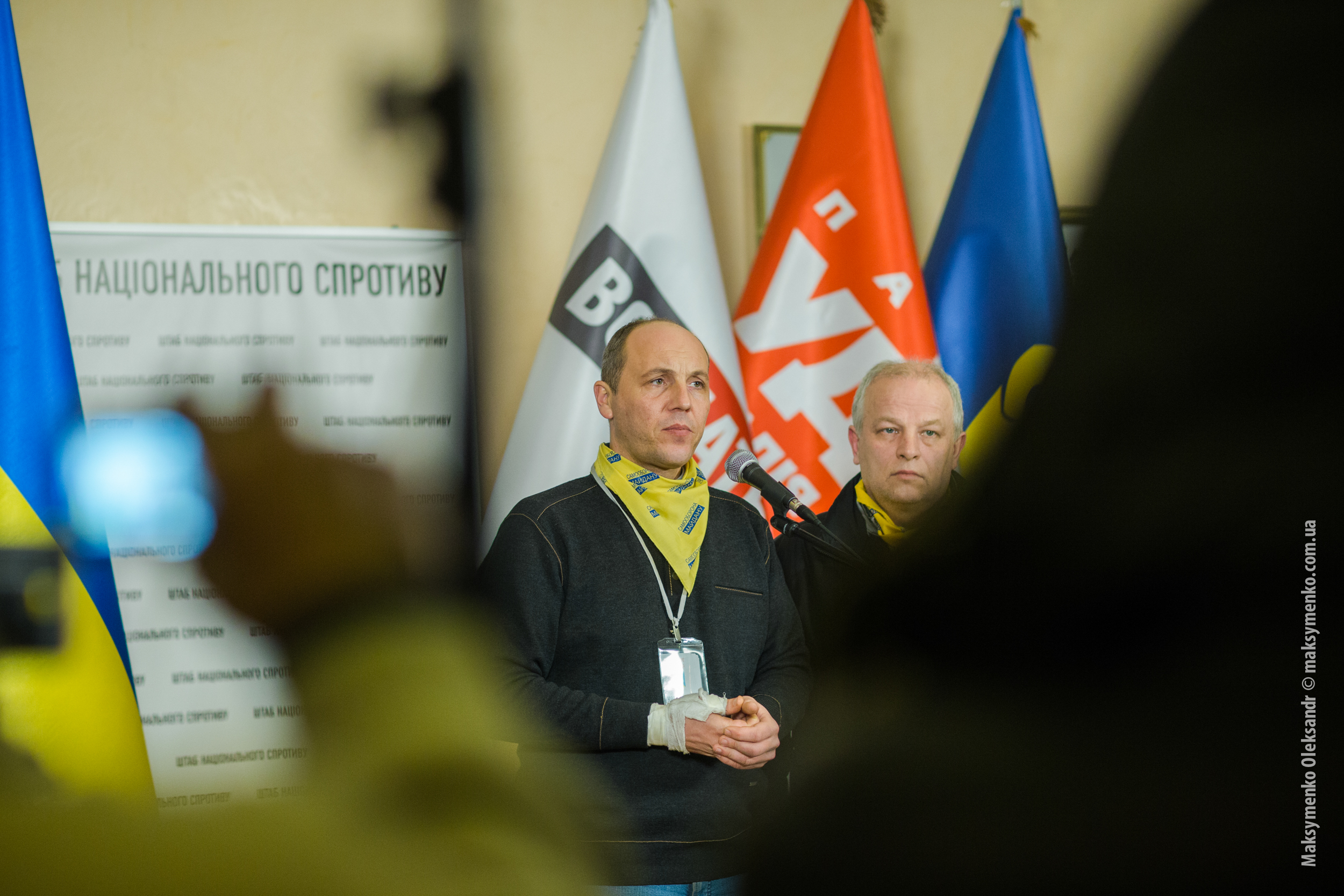 Andrij Parubij przemawia na tle flag, w kontekście zamachu we Lwowie.