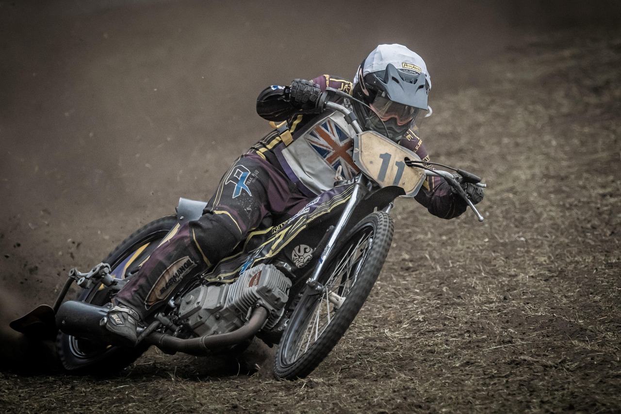 Żużlowiec z numerem 11 na motocyklu w zakręcie, tor w Holandii.