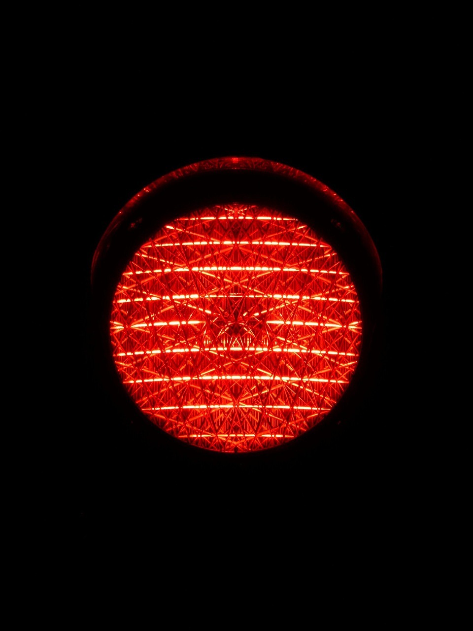 Czerwone światło sygnalizatora drogowego, symbolizujące kontrolę prędkości i potencjalne mandaty.