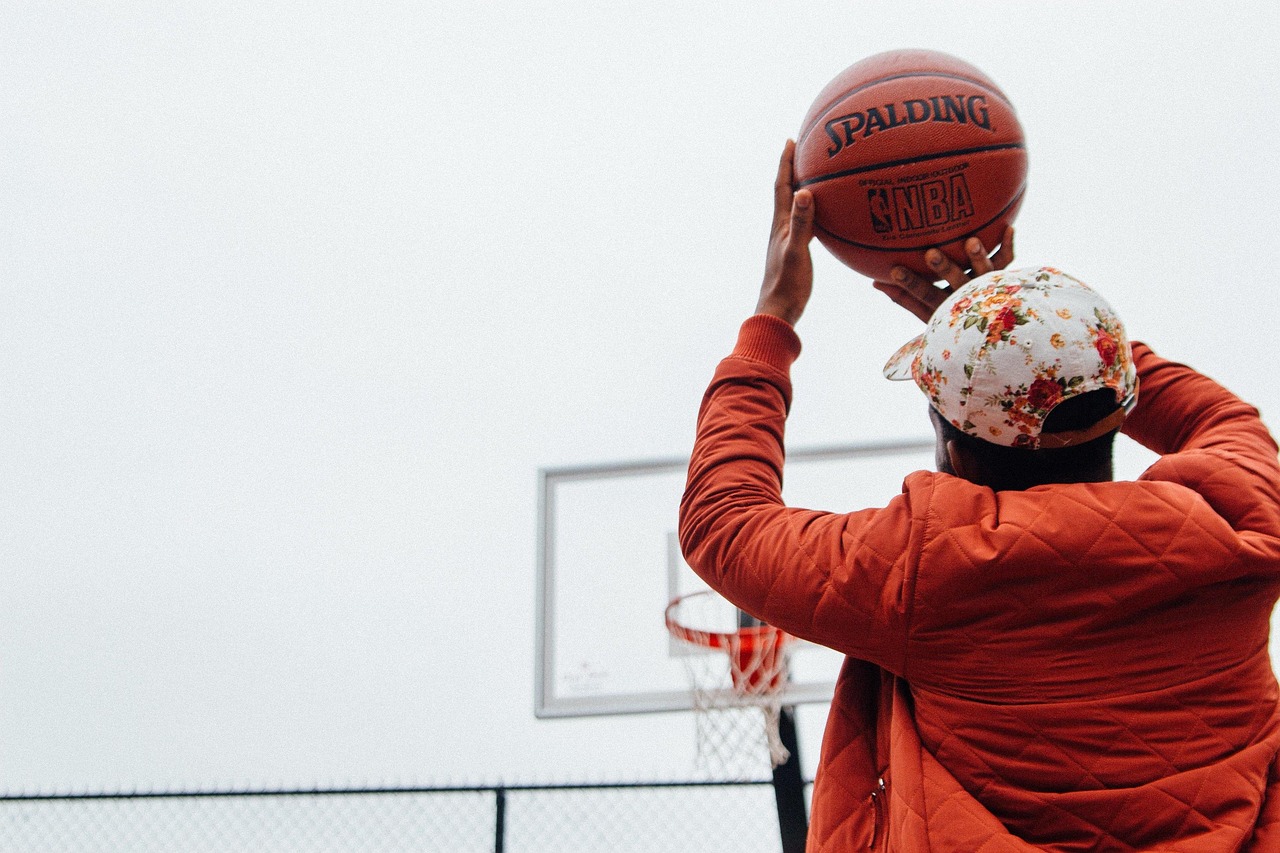 Gracz z piłką do koszykówki NBA w rękach, przygotowujący się do rzutu.