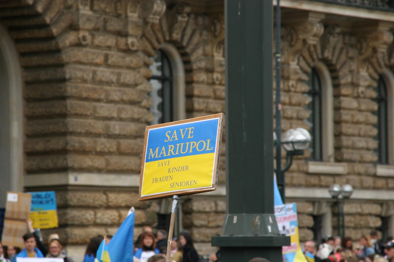 Transparent z napisem "SAVE MARIUPOL" i flagą Ukrainy, symbol solidarności z ofiarami ataku dronów.