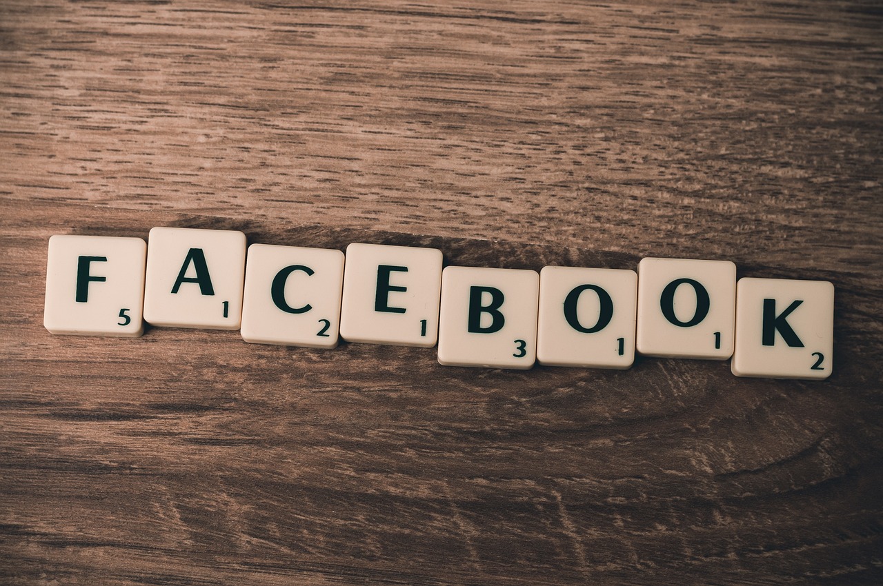 Litery na kafelkach tworzące słowo "FACEBOOK", symbolizujące media społecznościowe w komunikacji.