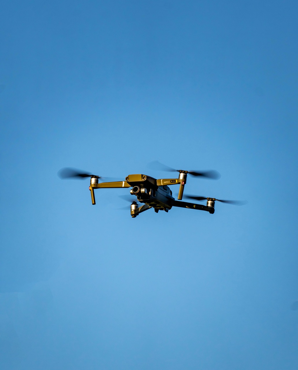 Dron latający na tle błękitnego nieba, kluczowy element artykułu o odkryciu drona przy granicy.