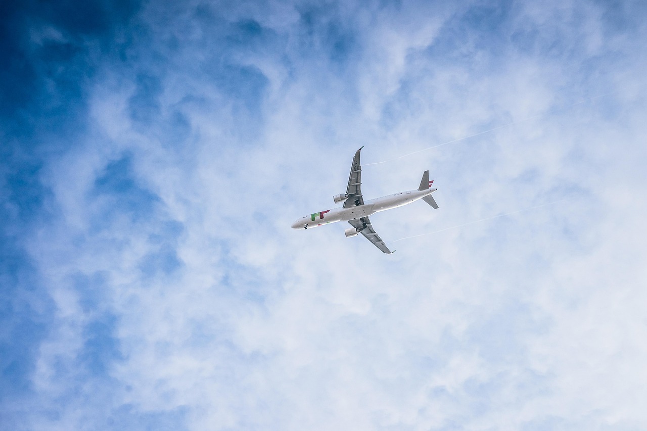 Samolot czarterowy Korean Air leci na tle błękitnego nieba z chmurami, wracając z USA.