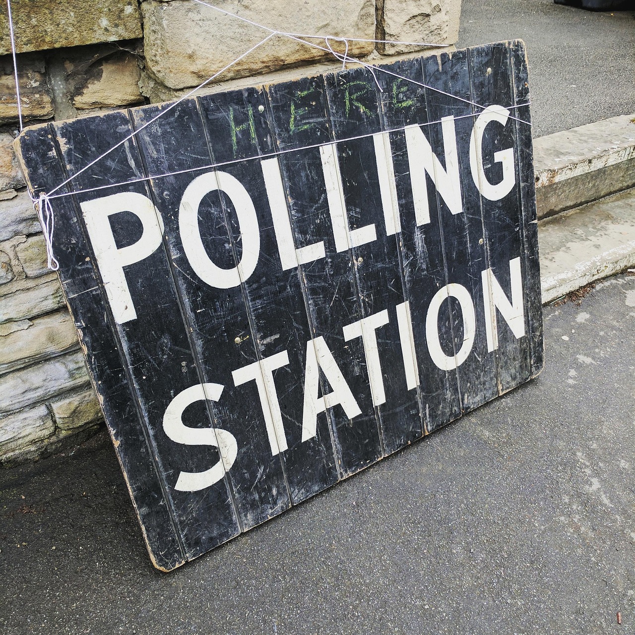 Znak "POLLING STATION" informujący o lokalizacji komisji wyborczej, kluczowy w kontekście nieprawidłowości wyborczych.