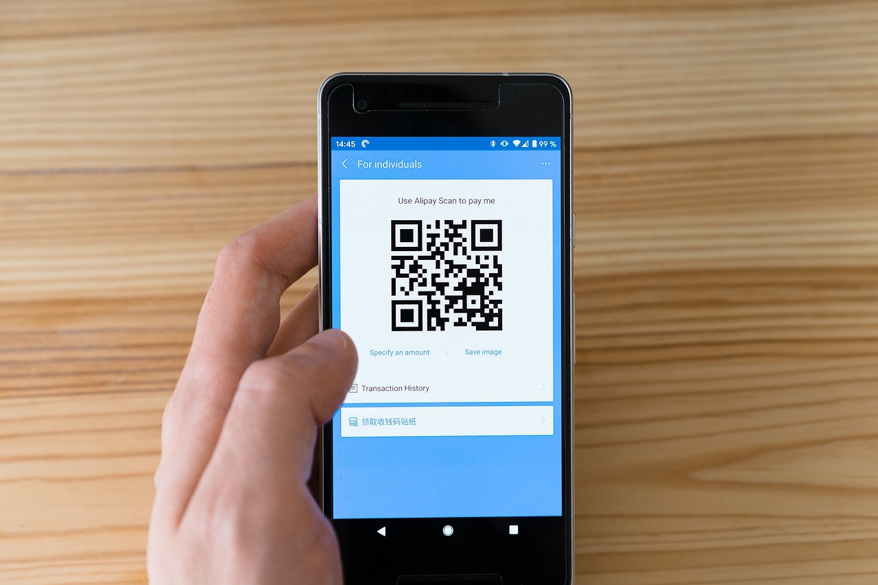 Młody Polak używa smartfona z kodem QR do płatności bezgotówkowych, ilustrując nawyki płatnicze.