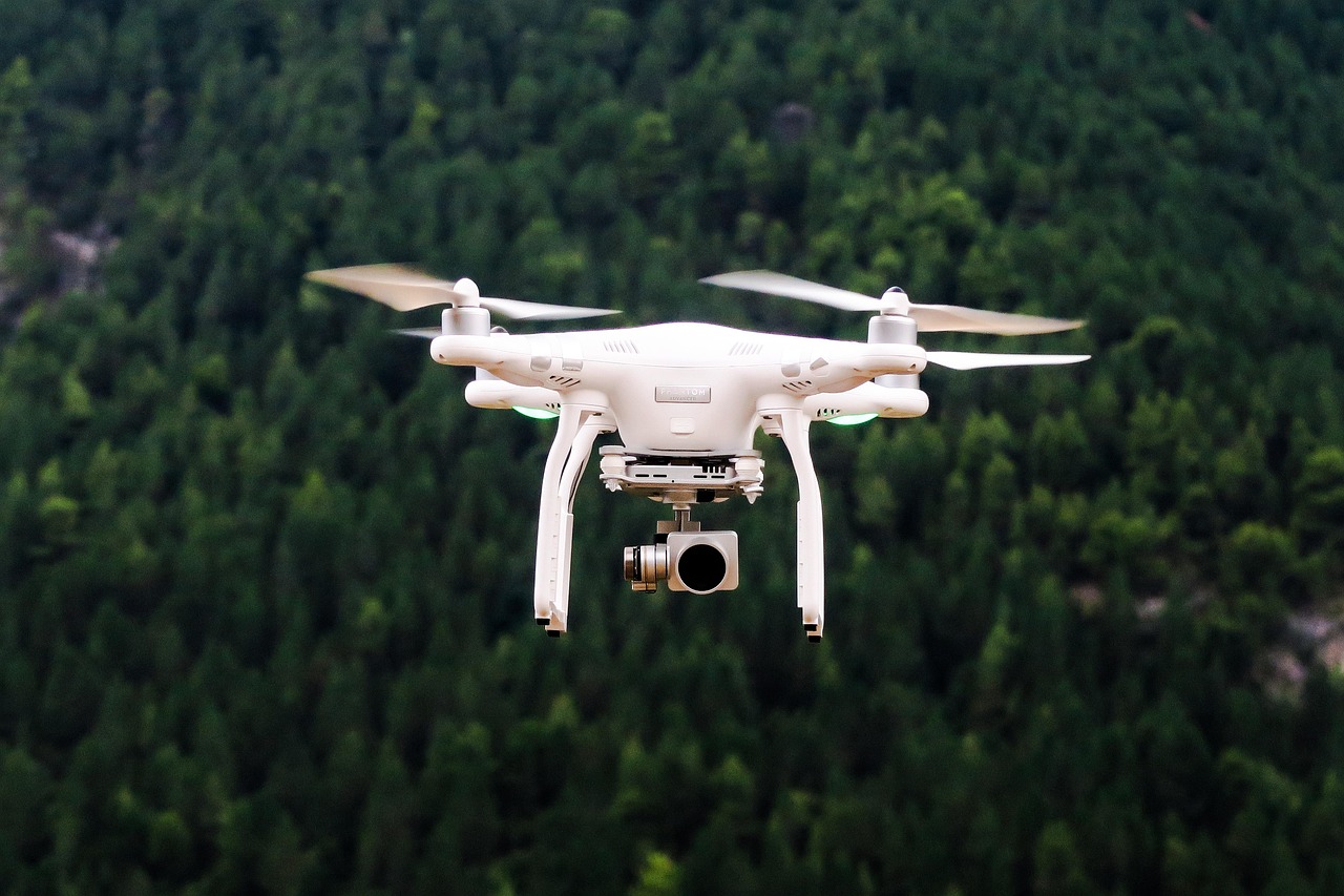 Biały dron latający na tle lasu, symbol rosyjskich dronów testujących NATO.