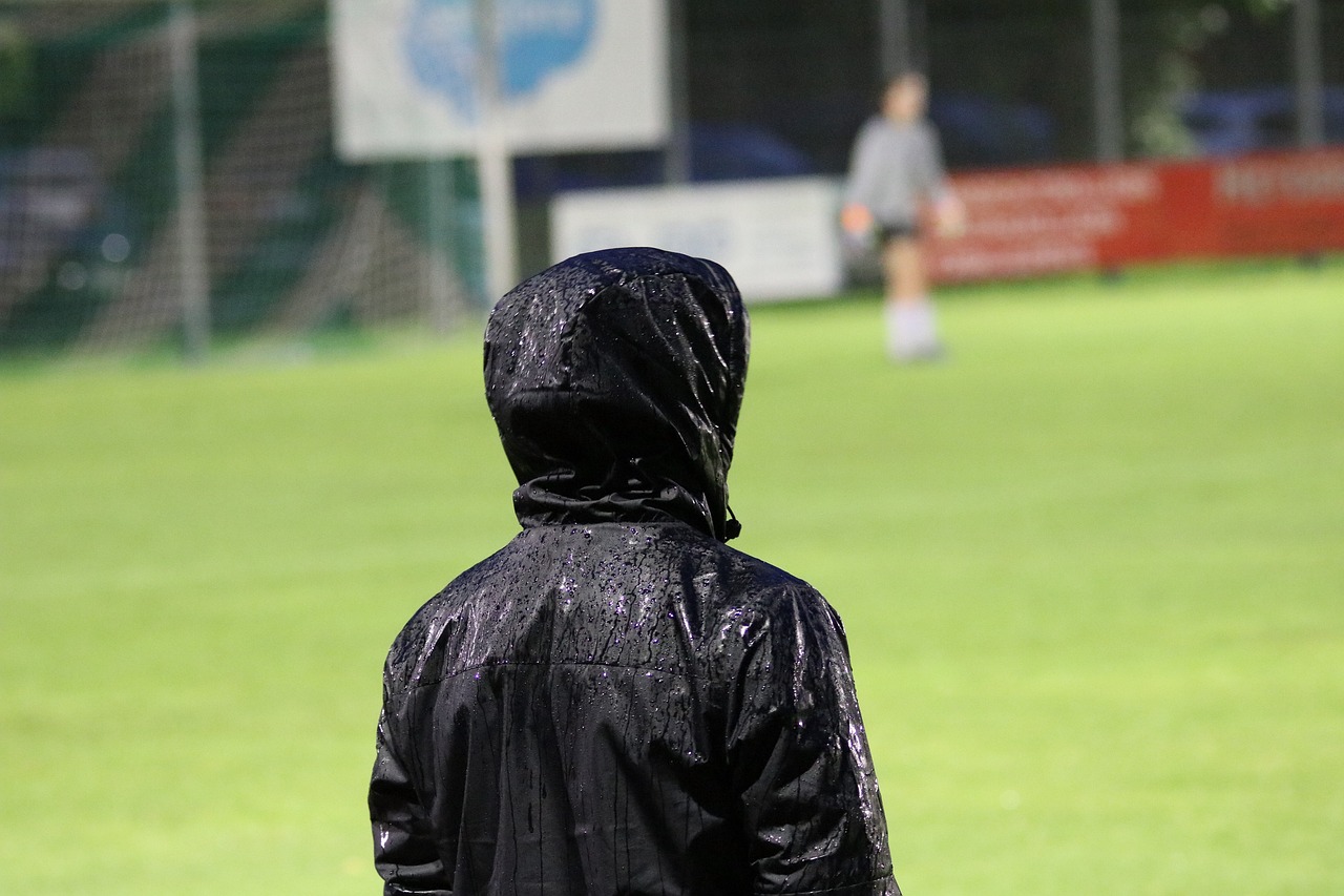 Piłkarka GKS Katowice w deszczowej kurtce na boisku, przygotowująca się do meczu w Europa Cup.