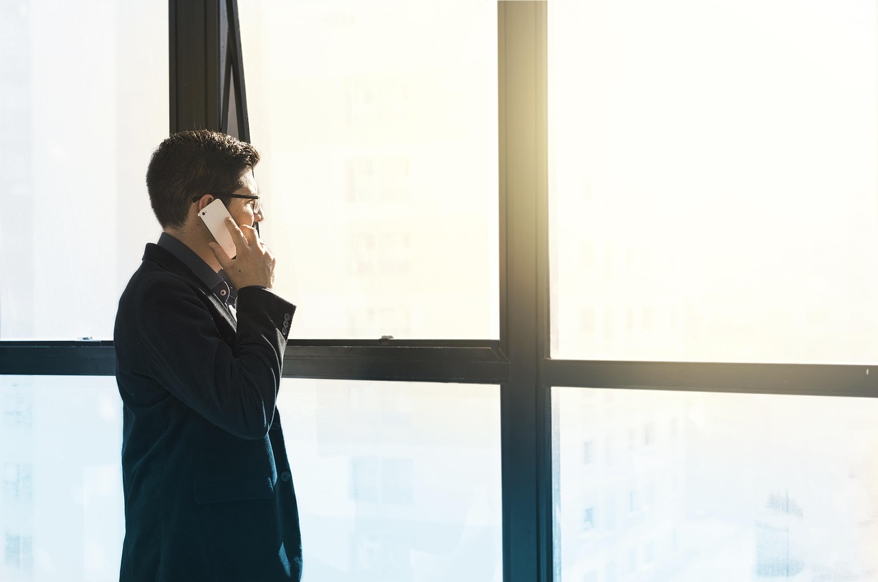 Mężczyzna rozmawia przez telefon, analizując ryzyko rachunku za roaming.