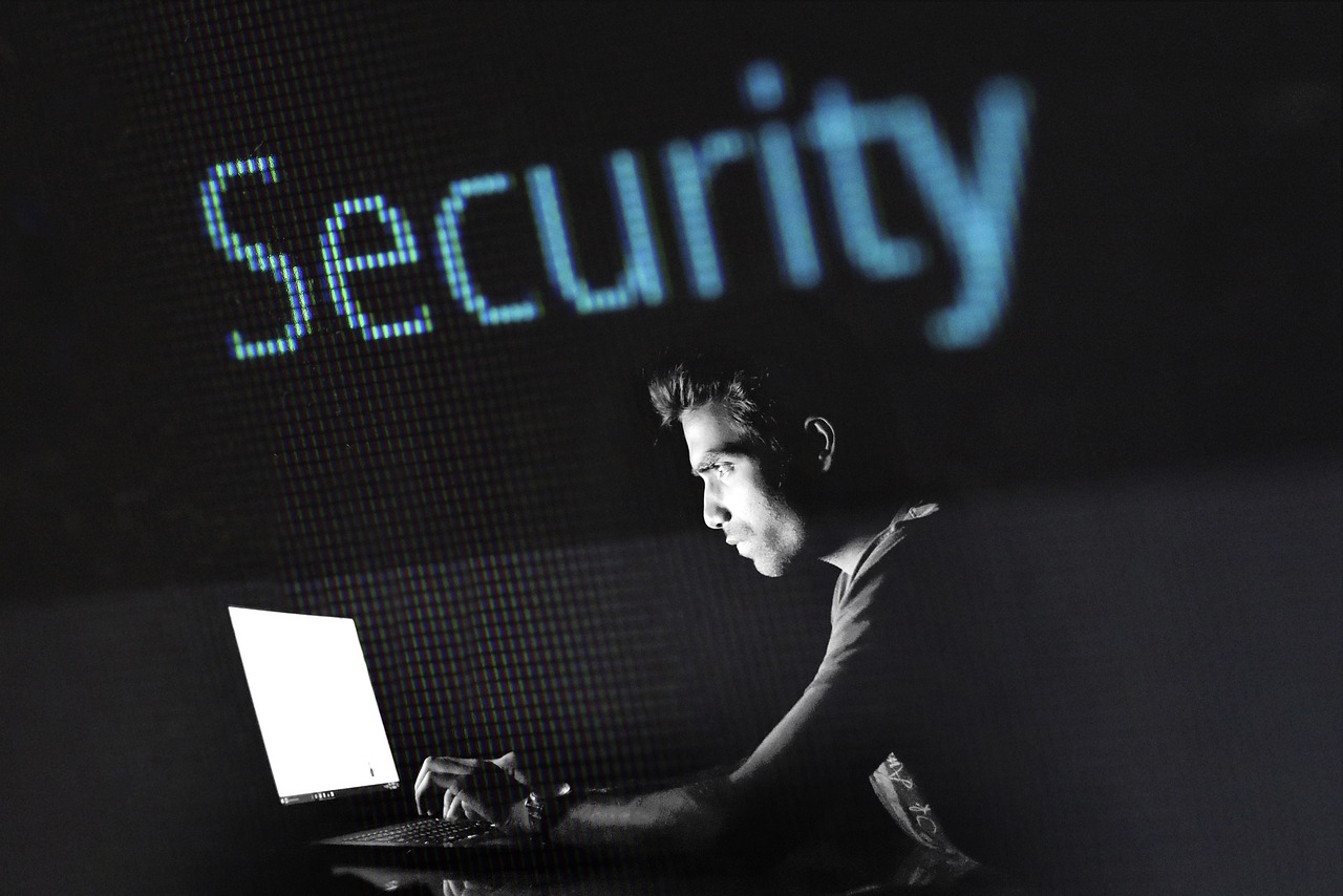 Mężczyzna pracujący na laptopie z napisem "Security" na ekranie, symbolizującym cyberbezpieczeństwo Finlandii.