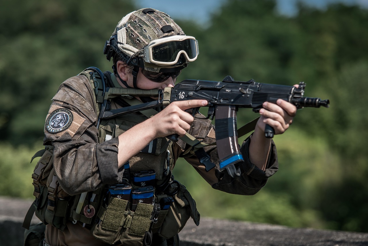 Żołnierz w pełnym rynsztunku bojowym celuje z karabinu, symbolizując potencjalny konflikt militarny w Wenezueli.