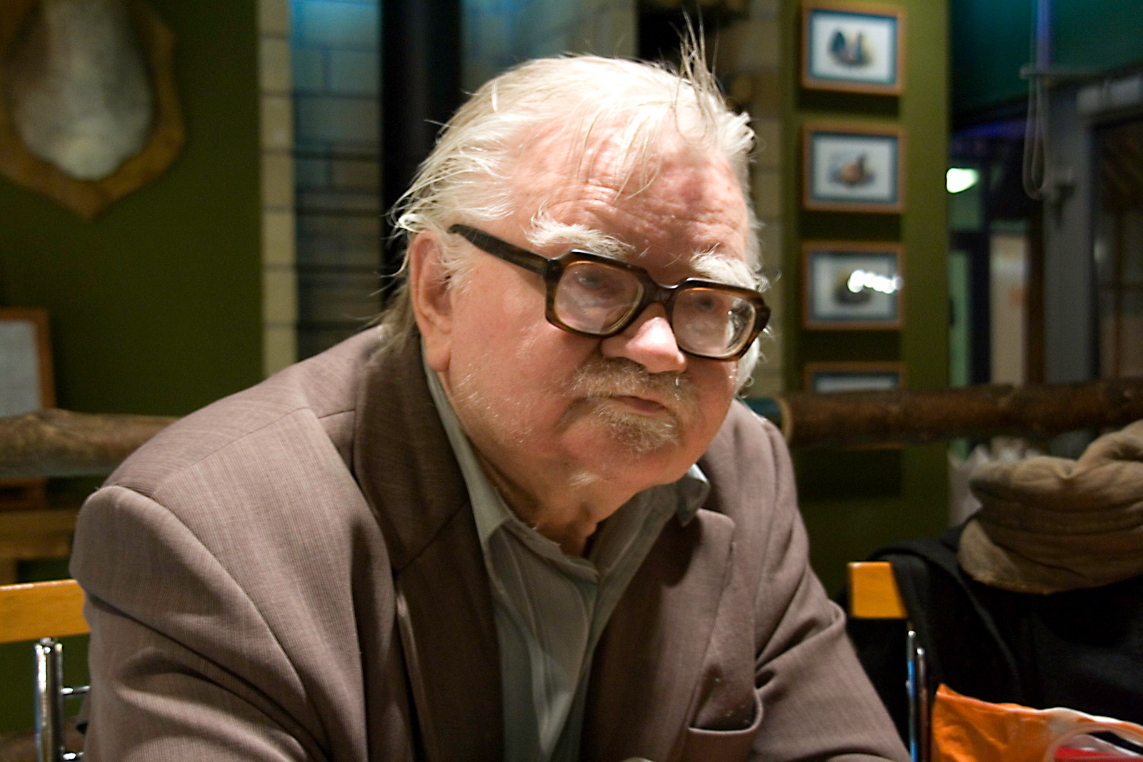 Krzysztof Janicki, legendarny spiker Nielby Wągrowiec, w okularach i brązowej marynarce.