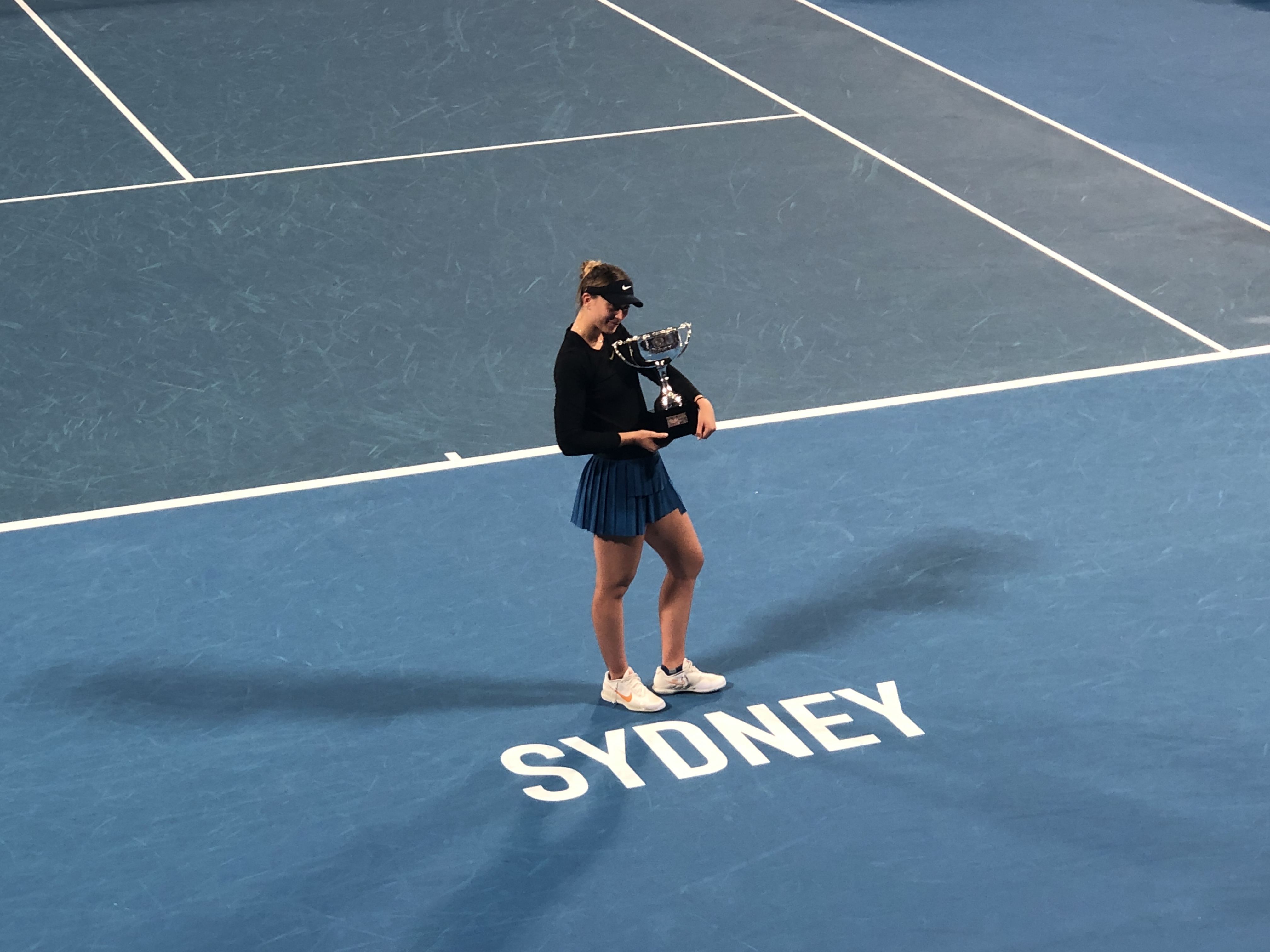 Paula Badosa trzyma puchar na korcie tenisowym w Sydney.