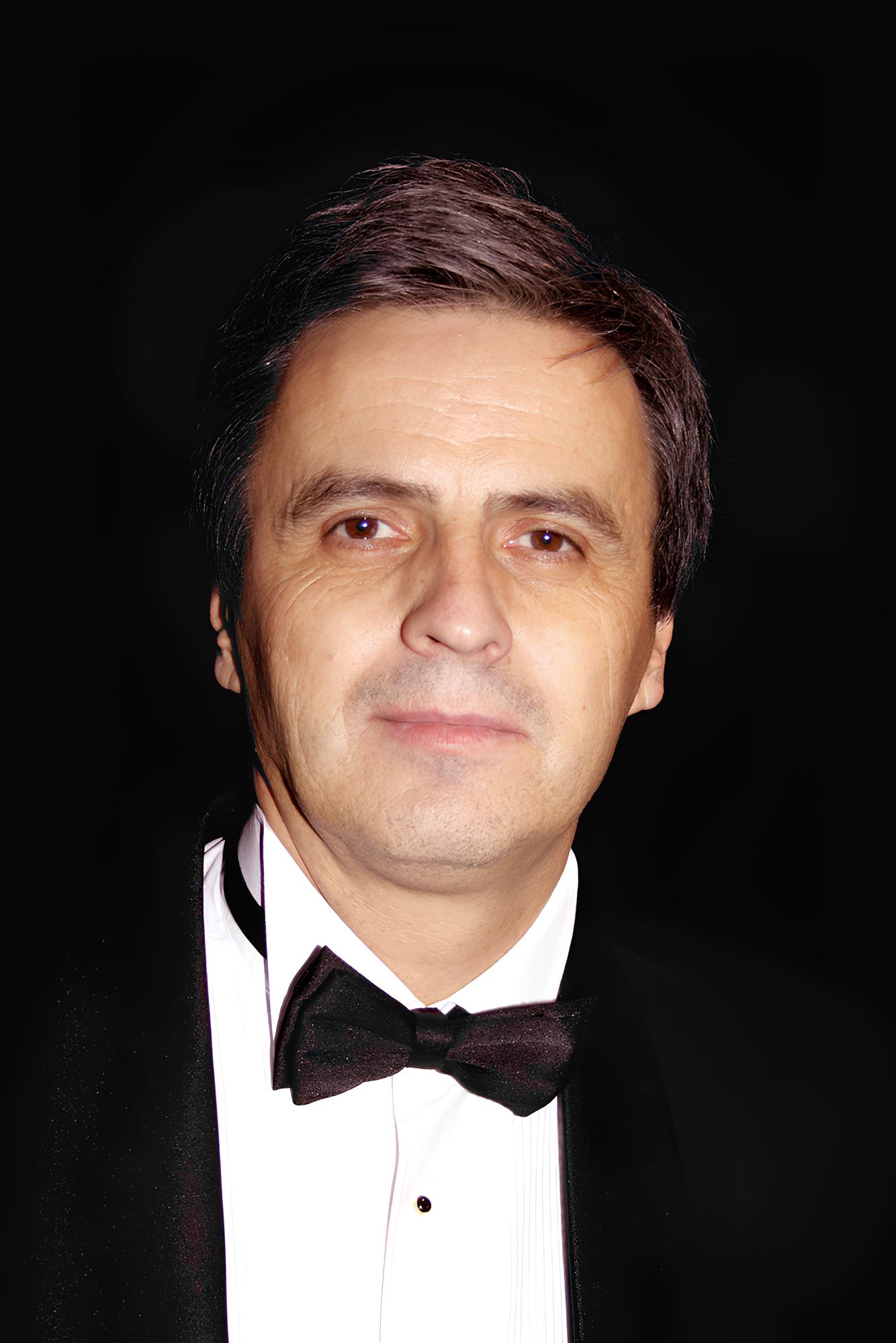 Piotr Polk w garniturze z muszką, aktor walczący z chorobą autoimmunologiczną.