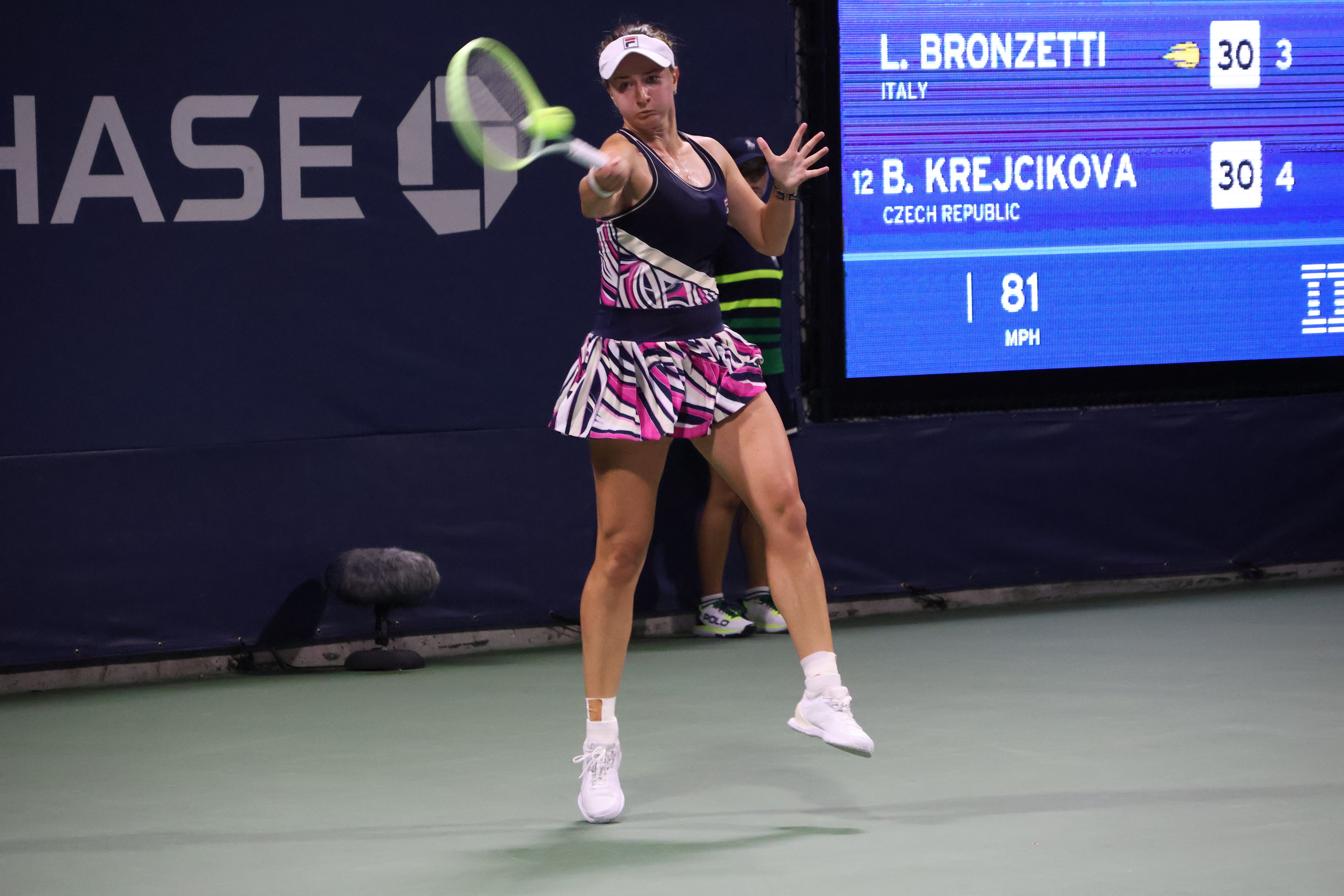 Barbora Krejcikova podczas meczu, widoczny wynik na tablicy.