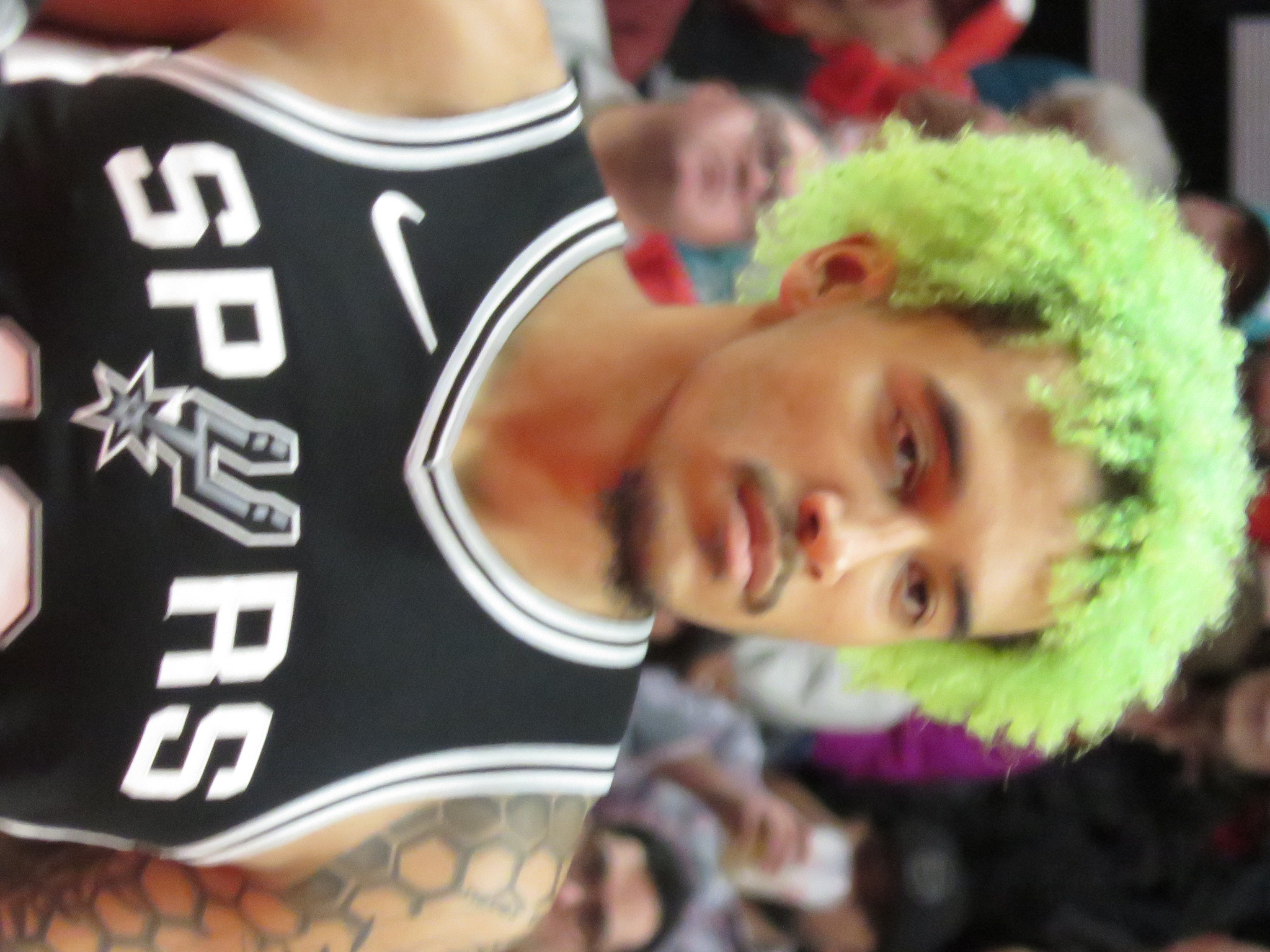 Jeremy Sochan w stroju San Antonio Spurs z zieloną fryzurą, gotowy do gry.