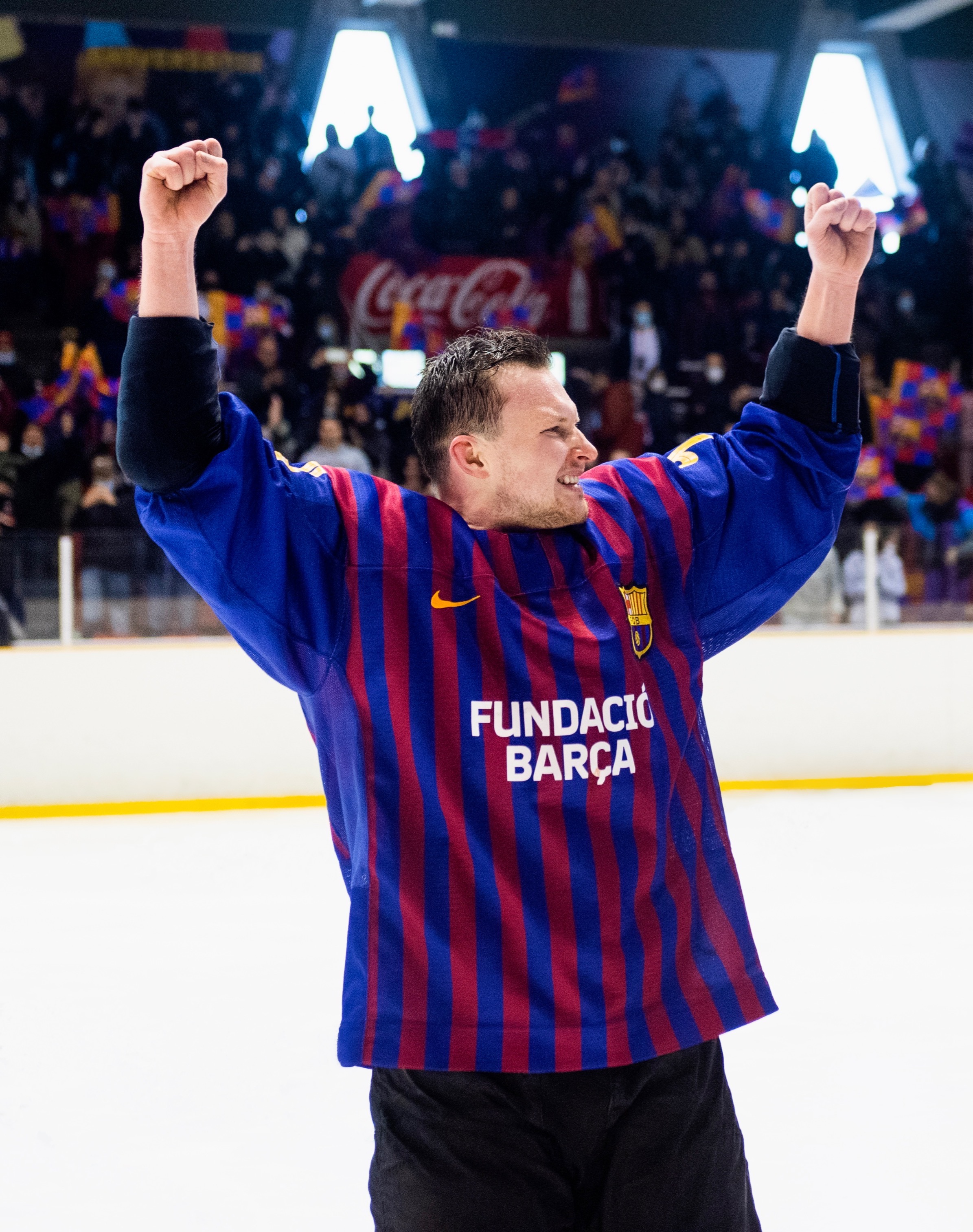 Piłkarz FC Barcelona w koszulce z Fundació Barça świętuje z podniesionymi rękami.