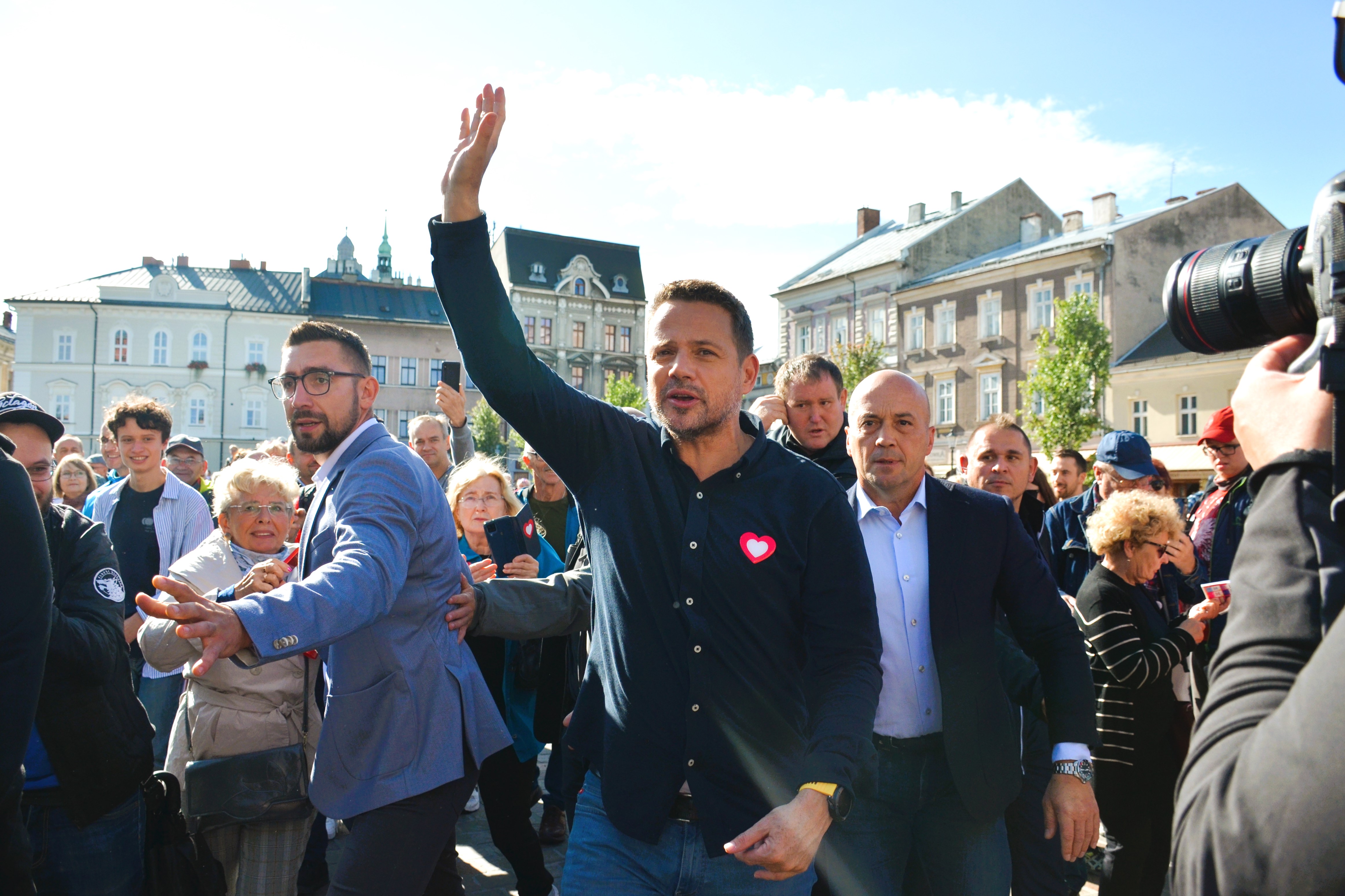 Rafał Trzaskowski wznosi rękę do góry, przemawiając do tłumu podczas wiecu.