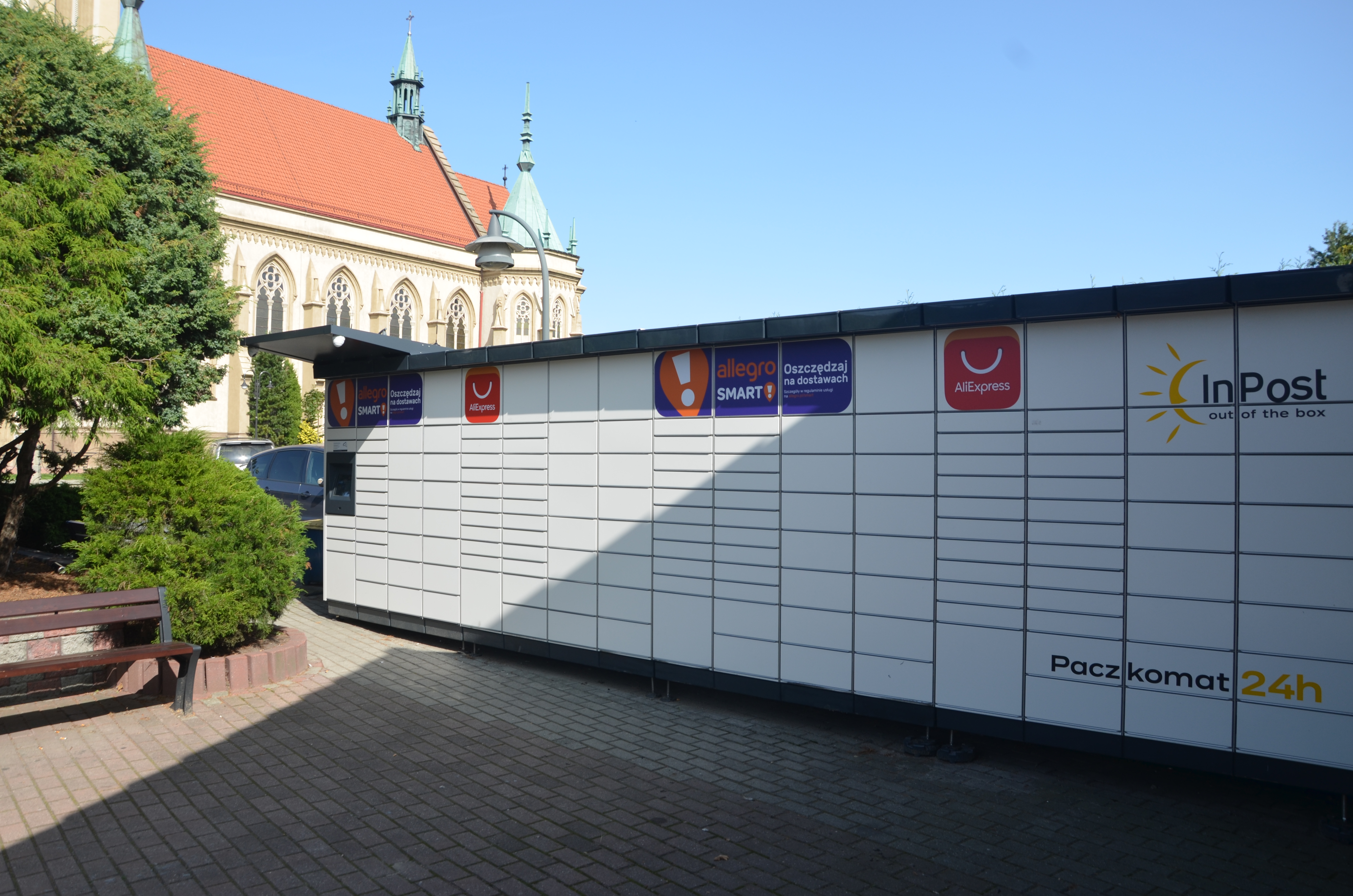 Paczkomat InPost z logo Allegro SMART i AliExpress, symbolizujący spory o metody dostawy.