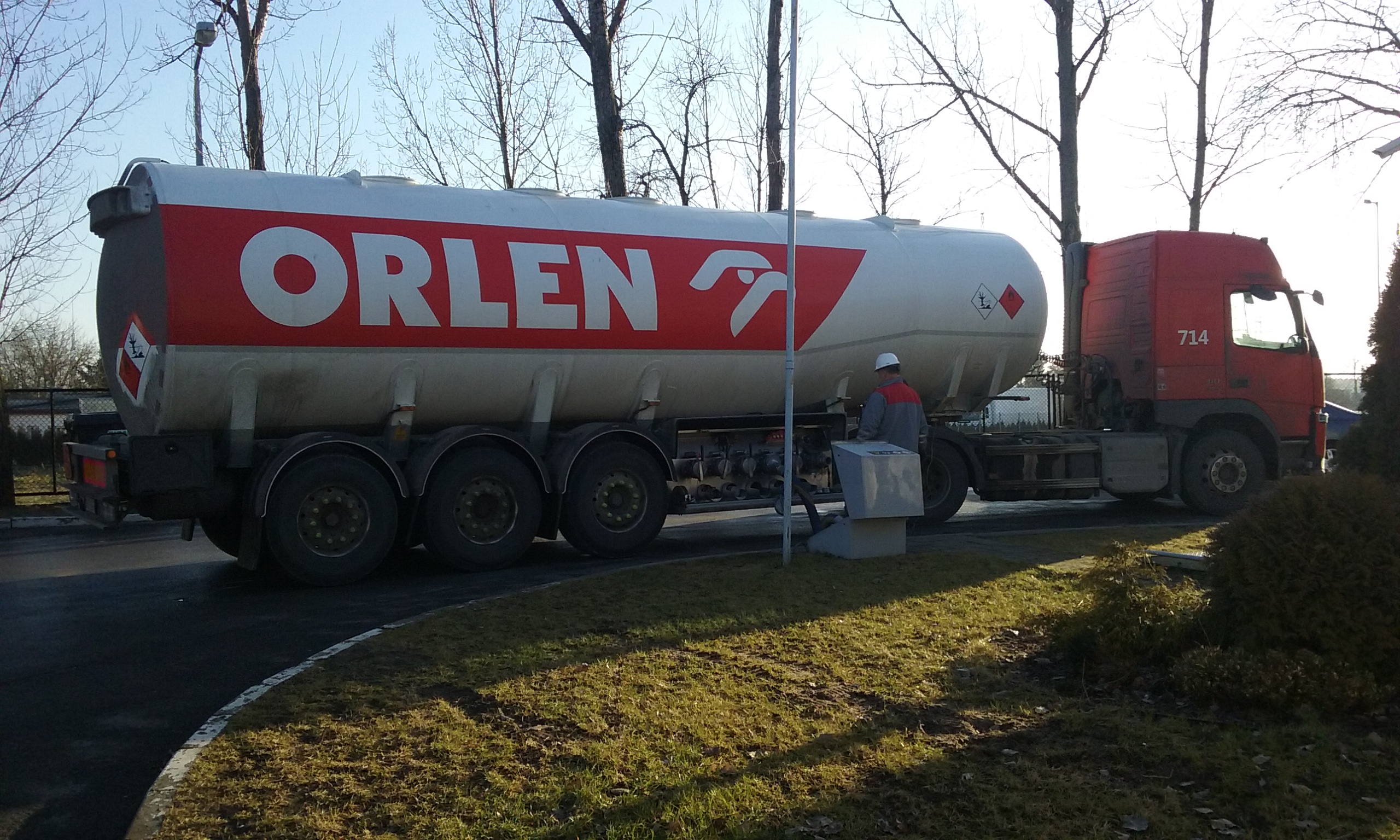 Ciężarówka cysterna Orlen z logo koncernu, symbolizująca działalność wydobywczą i transport paliw.