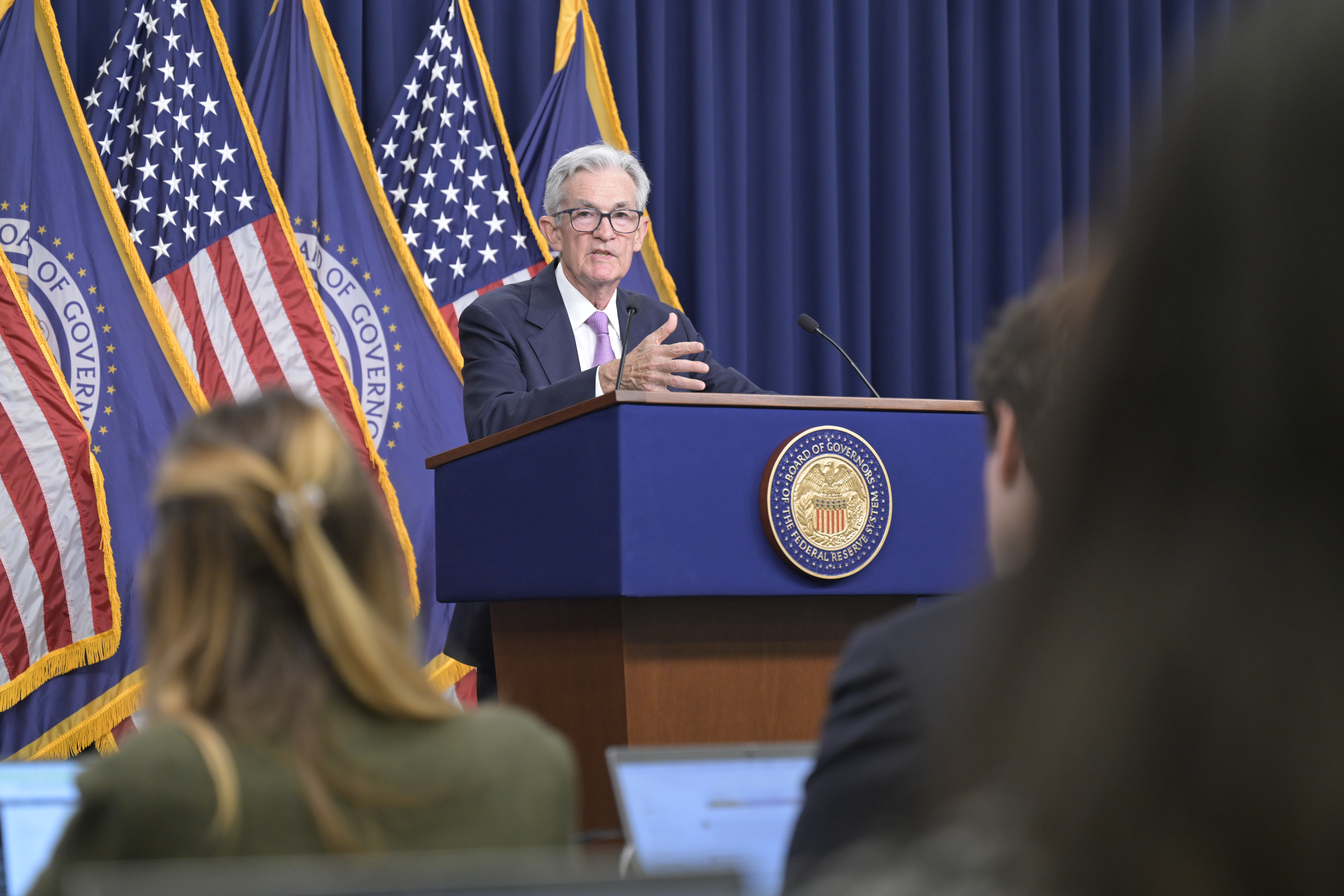Jerome Powell przemawia za mównicą z logo Rezerwy Federalnej, sygnalizując obniżkę stóp procentowych w USA.