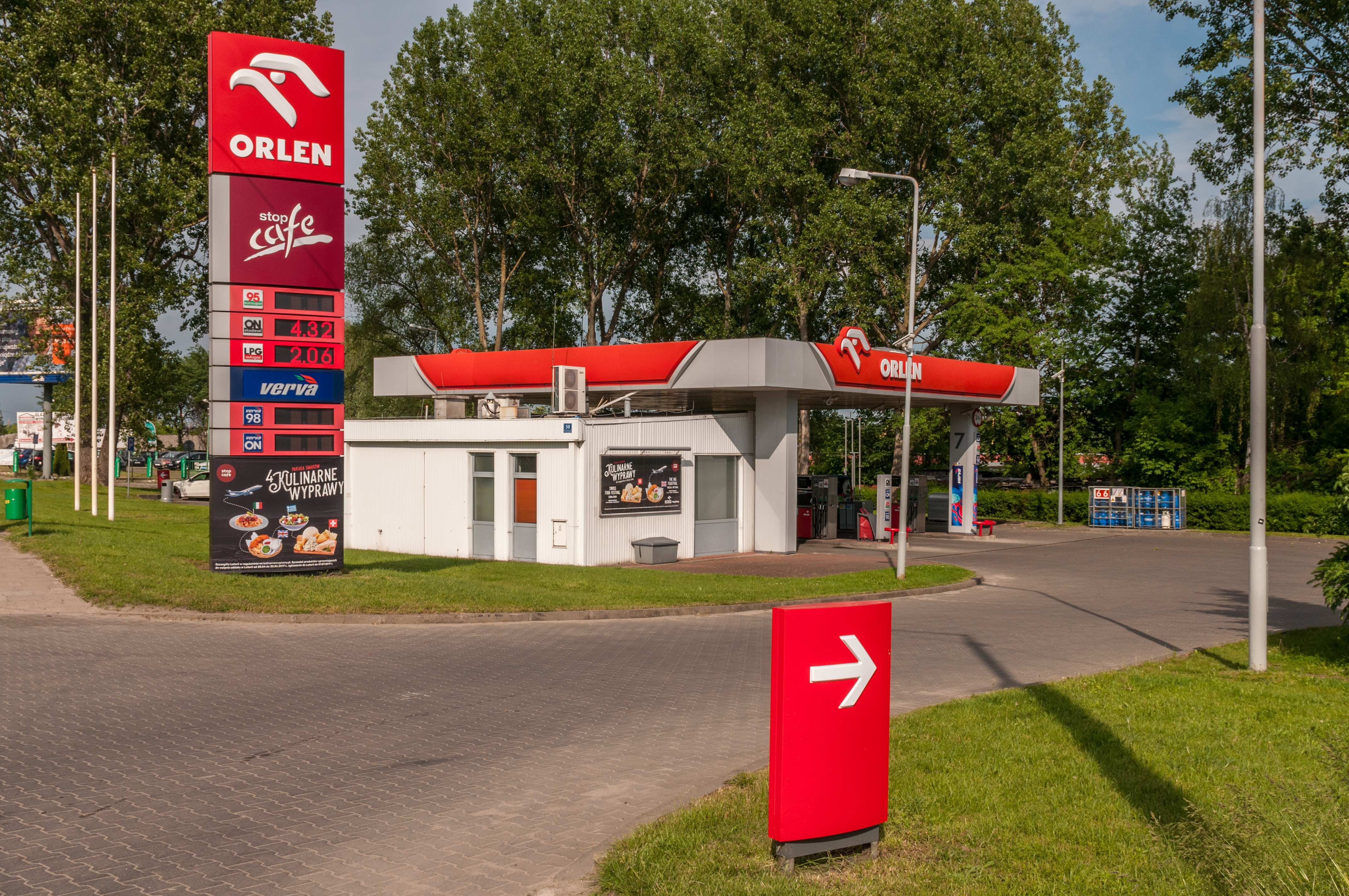 Stacja paliw Orlen z widoczną tablicą cen paliw i budynkiem sklepu.