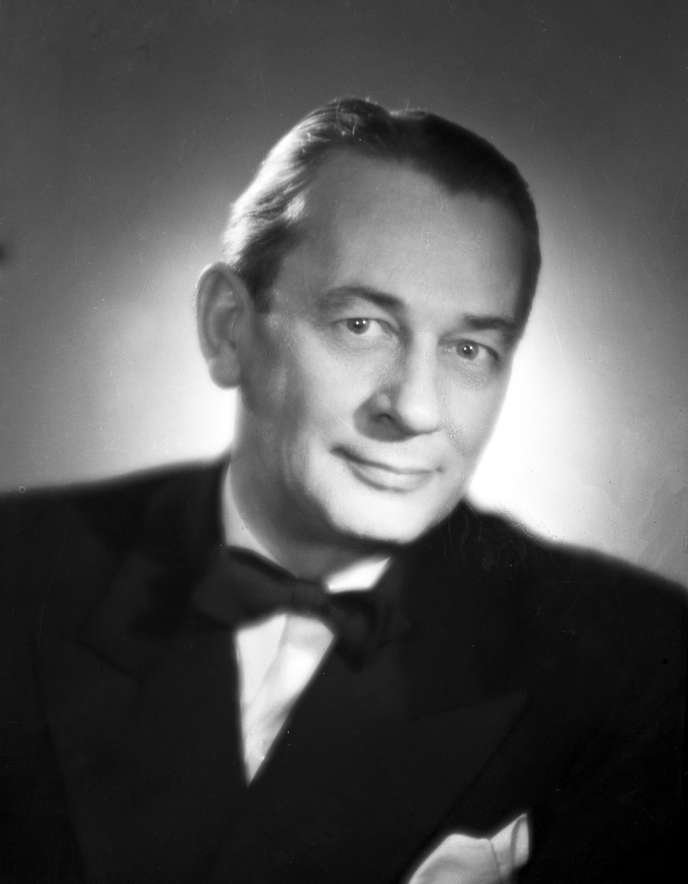 Portret Mieczysława Fogga, ikony polskiej muzyki, w eleganckim smokingu z muszką.