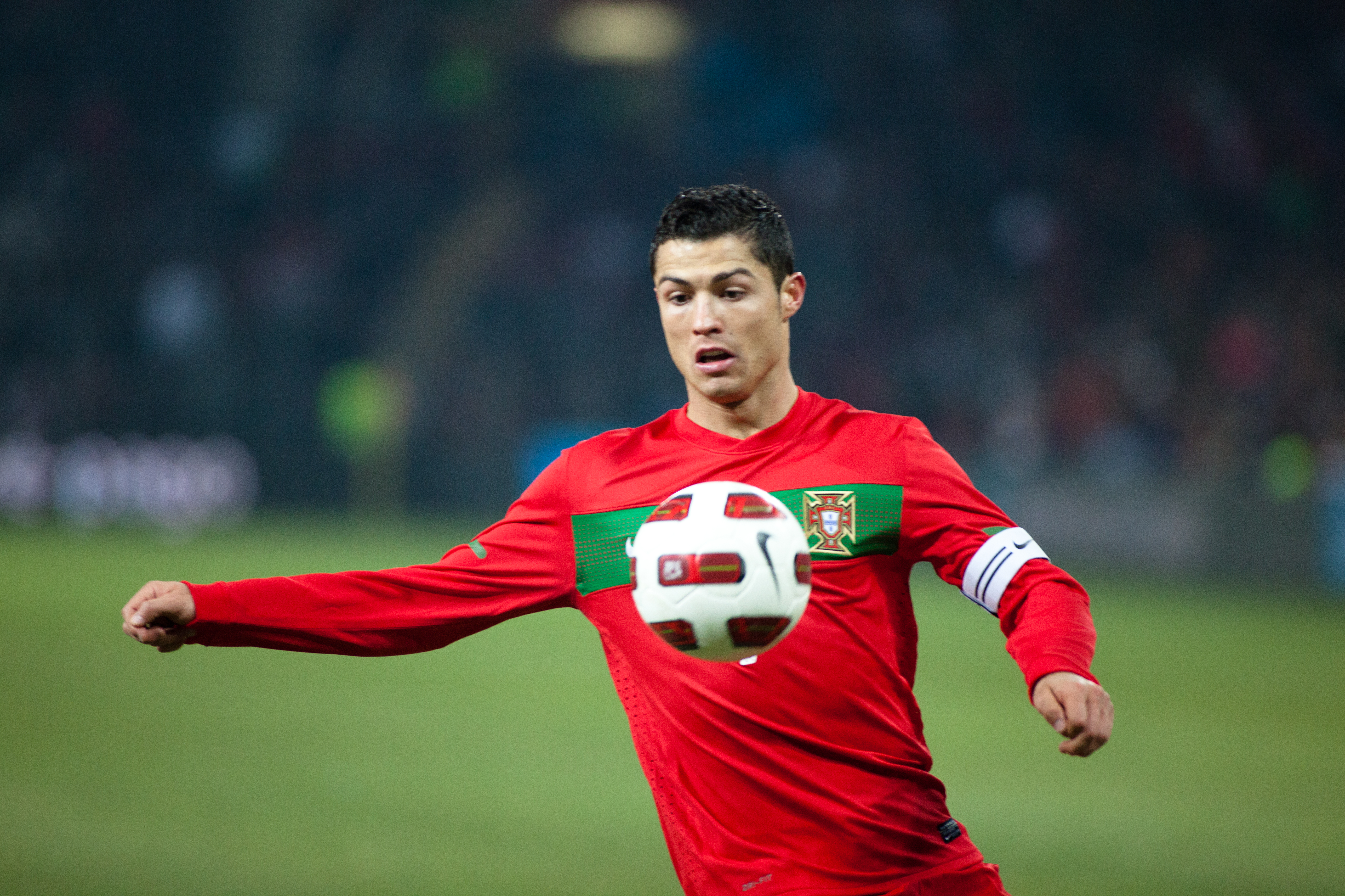 Cristiano Ronaldo w czerwonej koszulce reprezentacji Portugalii z piłką przy nodze.