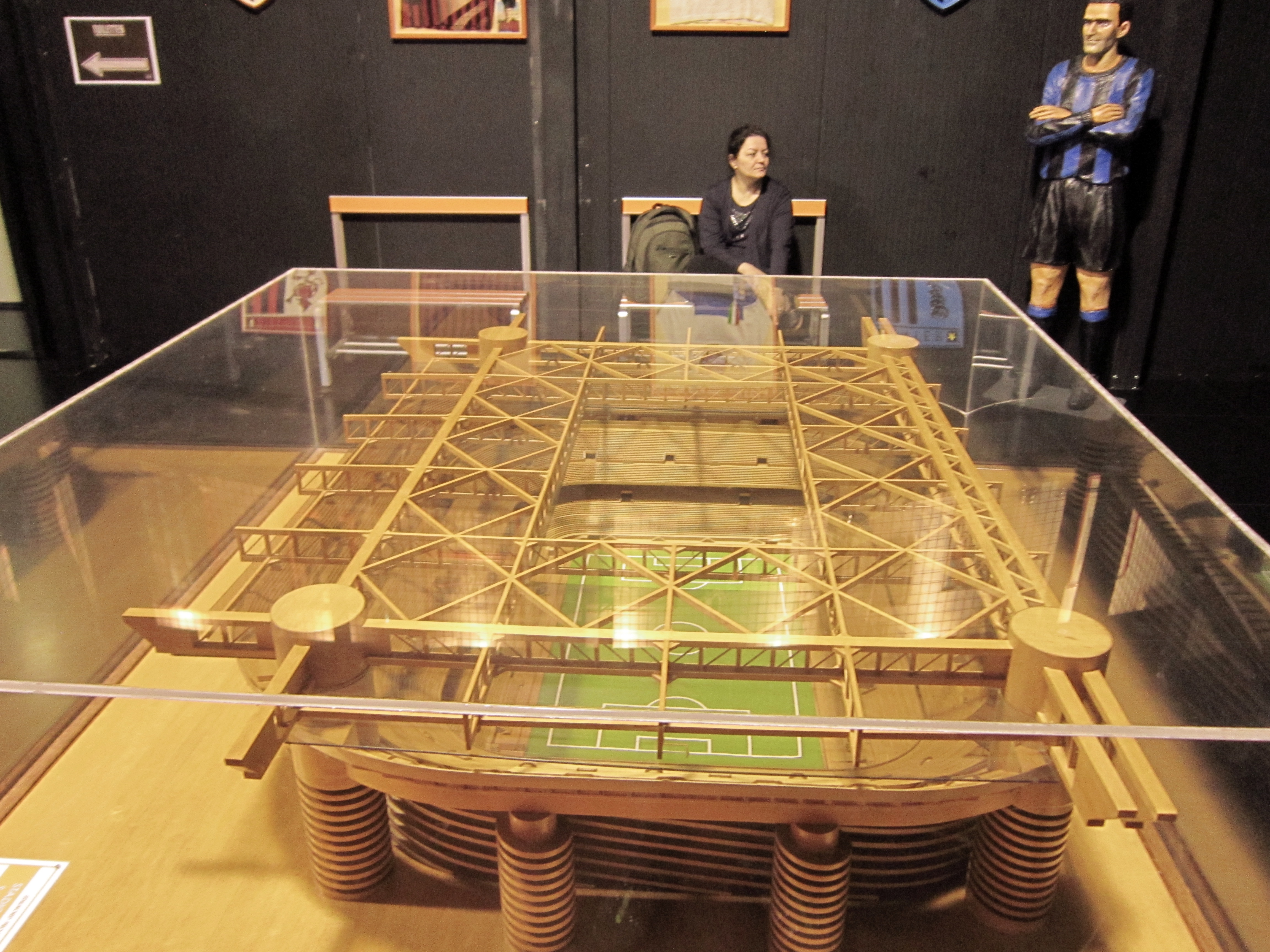 Model stadionu San Siro, domu Interu Mediolan, z figurą piłkarza w tle.
