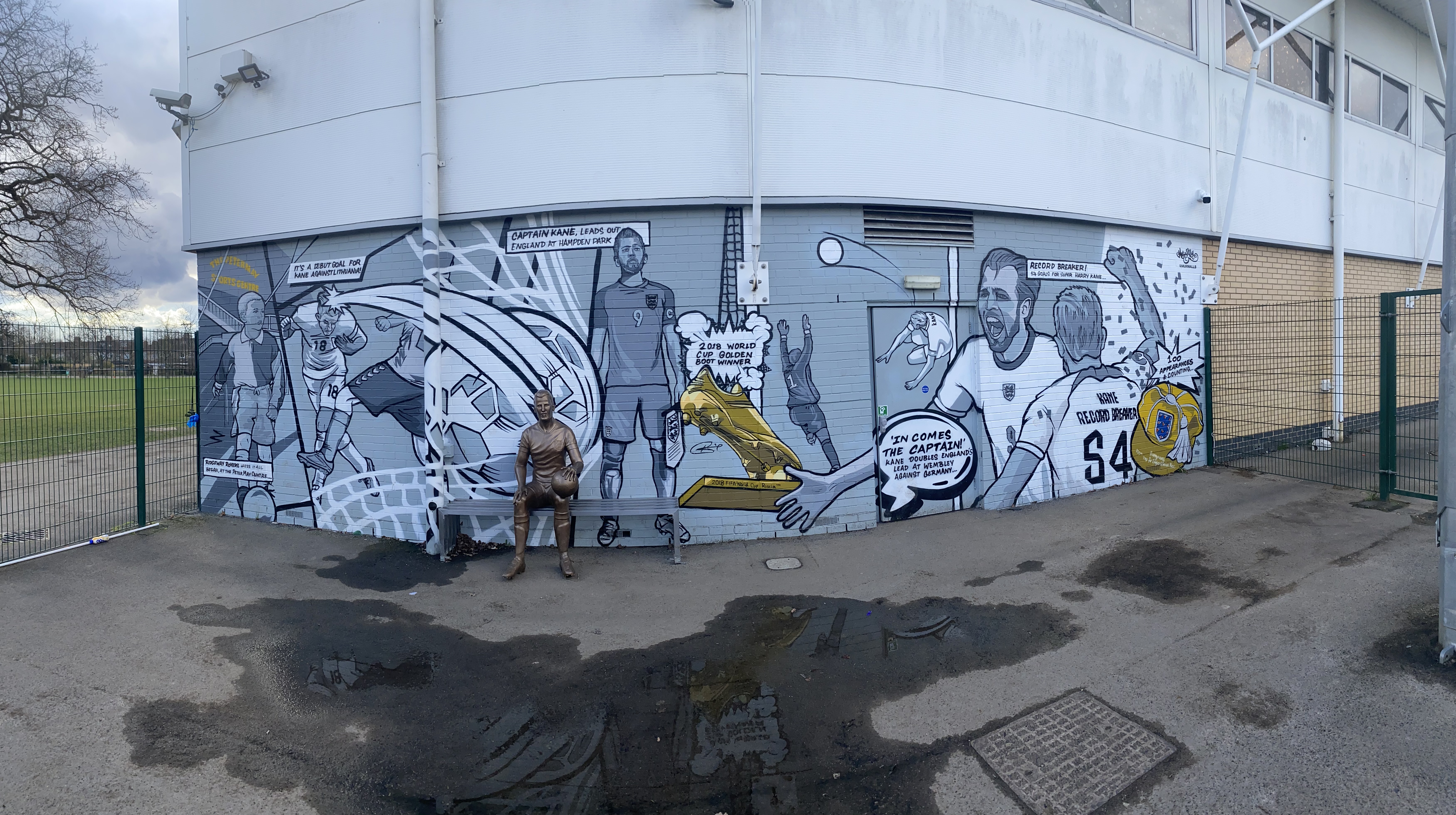 Mural z Harrym Kane'em i złotym butem, przedstawiający jego karierę i sukcesy.