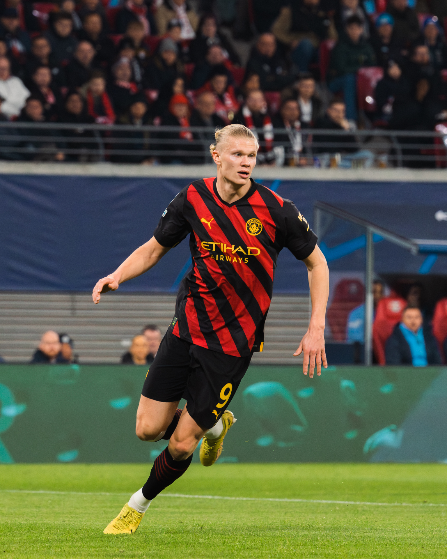 Erling Haaland w koszulce Manchesteru City z numerem 9, biegający po boisku.