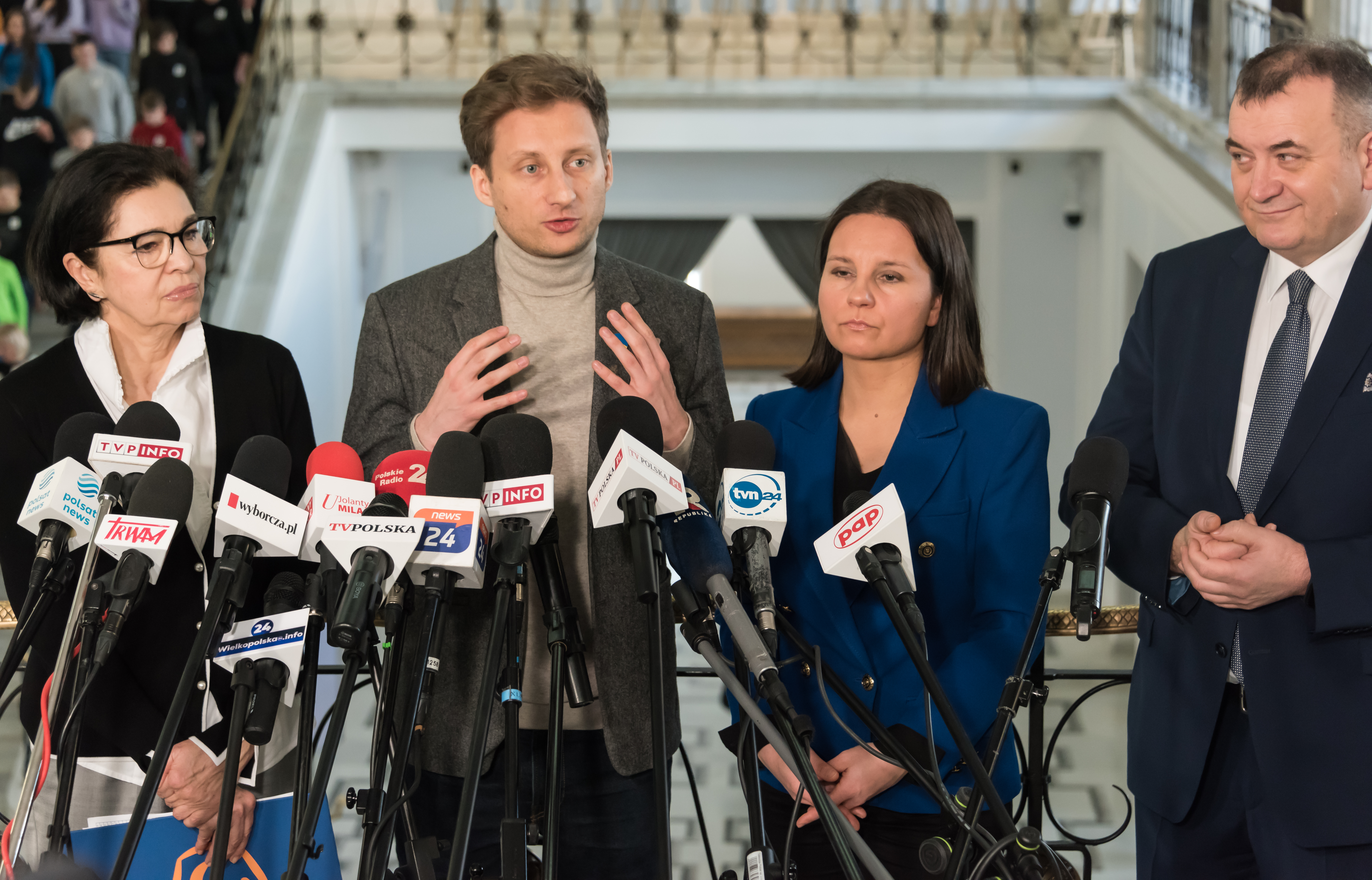 Poseł Franciszek Sterczewski przemawia na konferencji prasowej z innymi politykami i dziennikarzami.