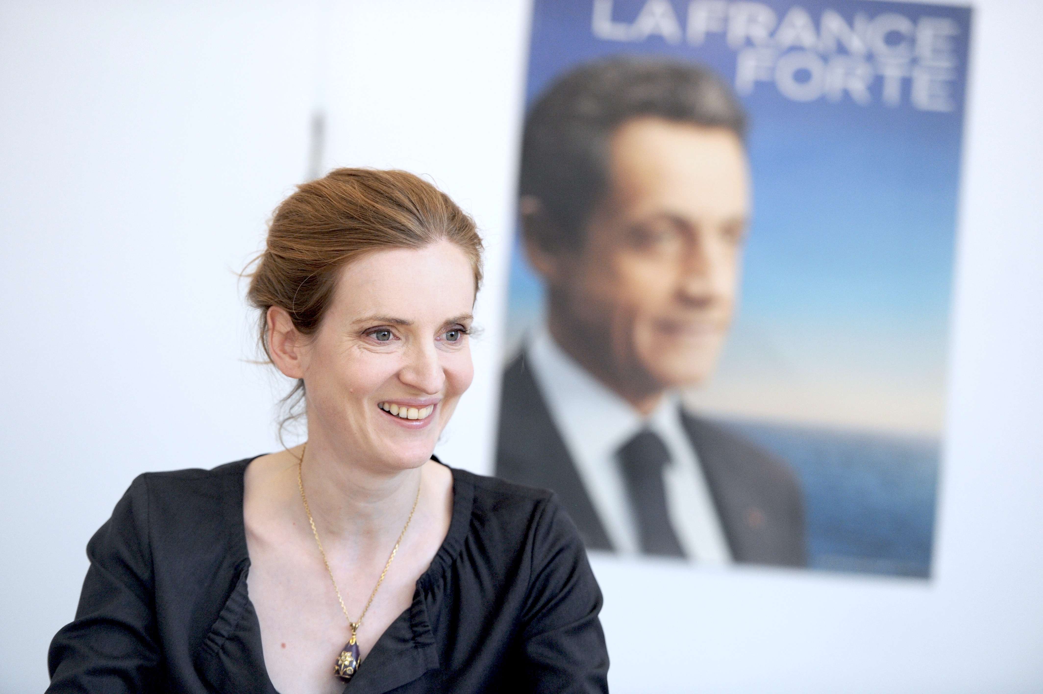 Nicolas Sarkozy na plakacie wyborczym "La France Forte" w tle artykułu o jego wyroku.