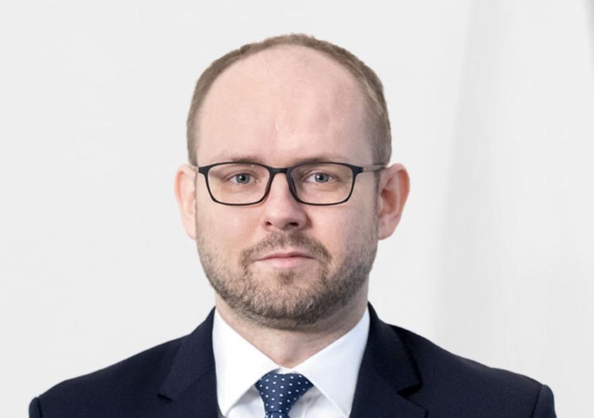 Marcin Przydacz w garniturze, polityk pasjonujący się futbolem.