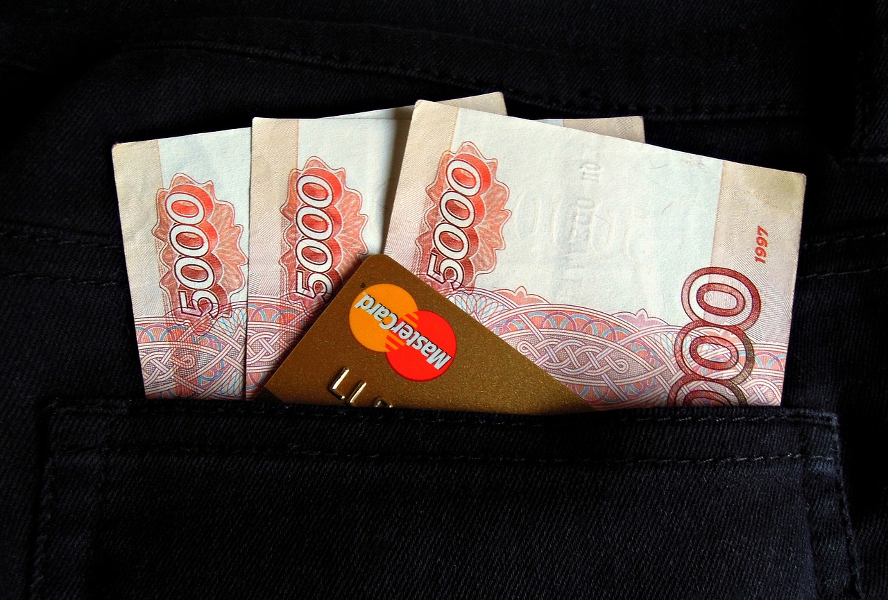 Rosyjskie banknoty 5000 rubli i karta Mastercard w kieszeni, symbolizujące konfiskatę majątku i ryzyko inwestycyjne w Rosji.