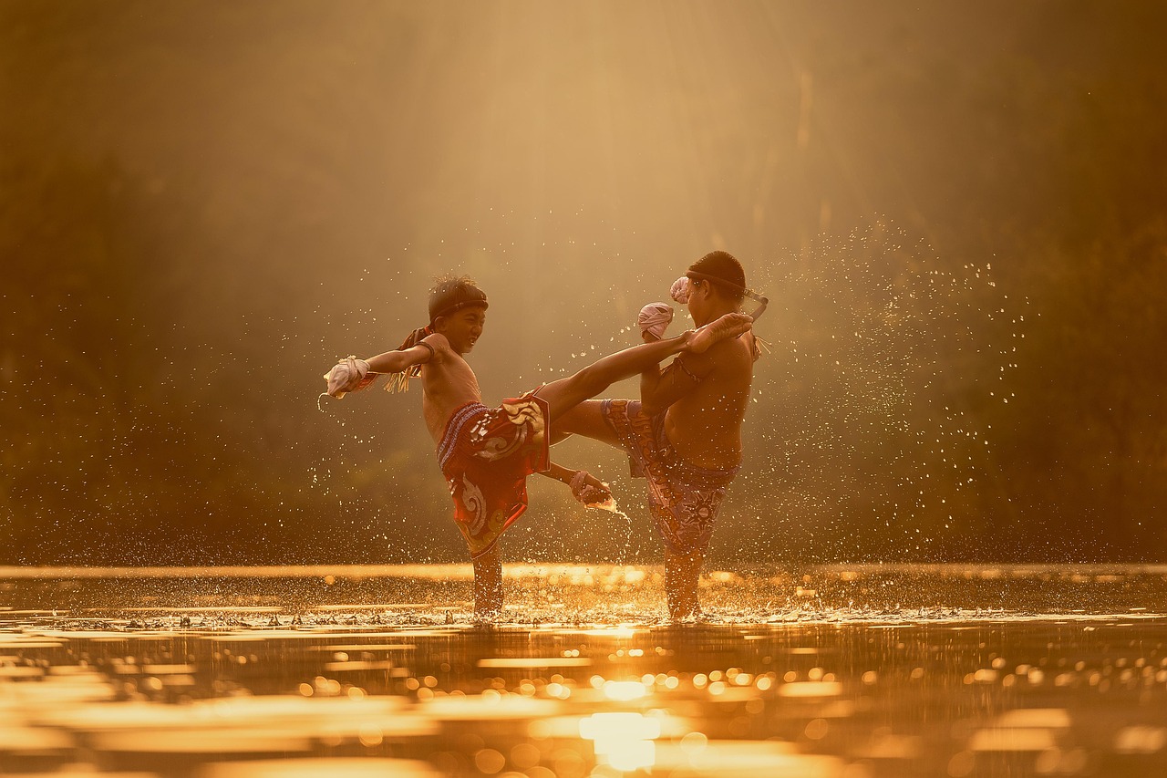 Dwóch chłopców trenujących Muay Thai na wodzie, symbol walki i determinacji.