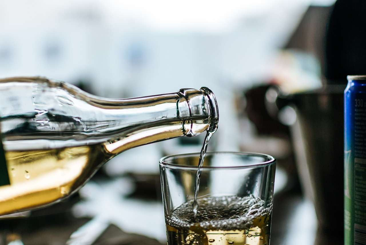 Nalewanie alkoholu do szklanki, symbolizujące jazdę pod wpływem alkoholu i konfiskatę auta.