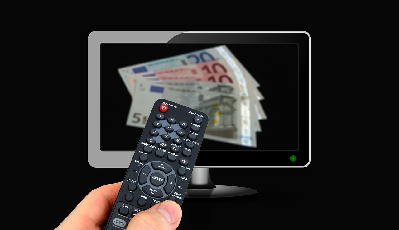 Pieniądze na ekranie telewizora symbolizujące nowe opłaty dla kierowców i ich wpływ na portfel.