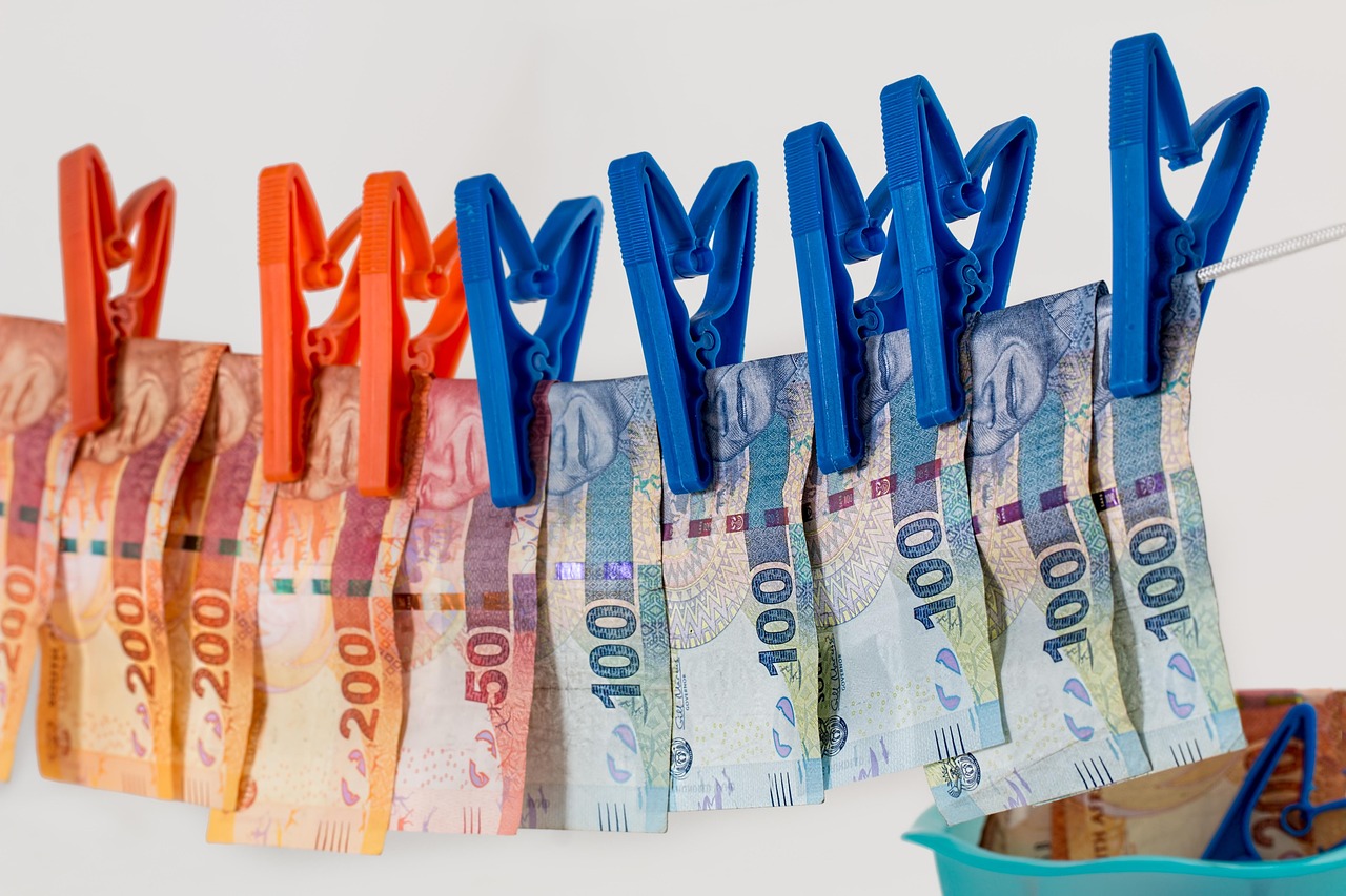 Pieniądze suszące się na sznurku, symbolizujące finansowe problemy i burzę w klubie żużlowym.