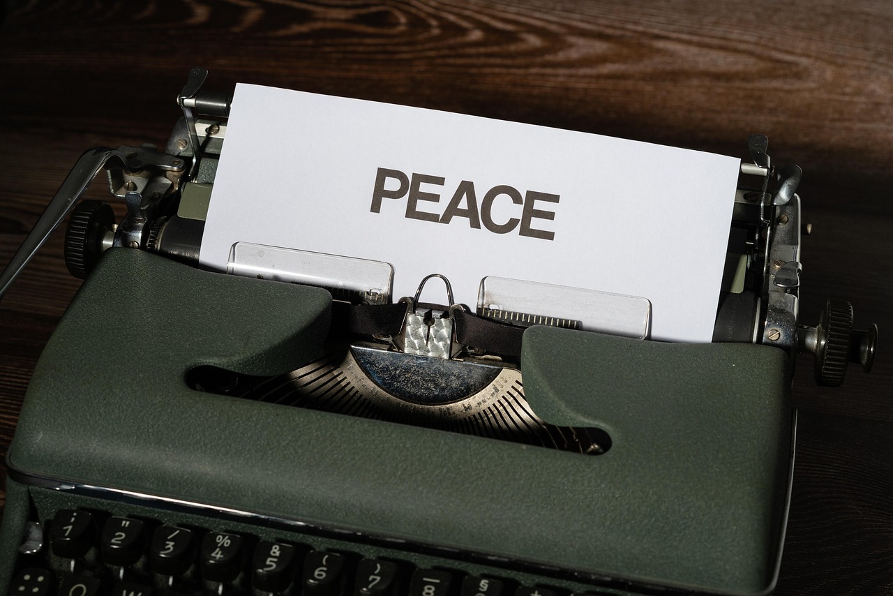 Maszyna do pisania z kartką papieru z napisem "PEACE" - symbol nadziei na pokój w Gazie.