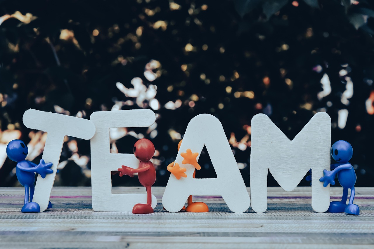 Figurki wspierające napis TEAM, symbolizujące siłę drużyny w żużlu.