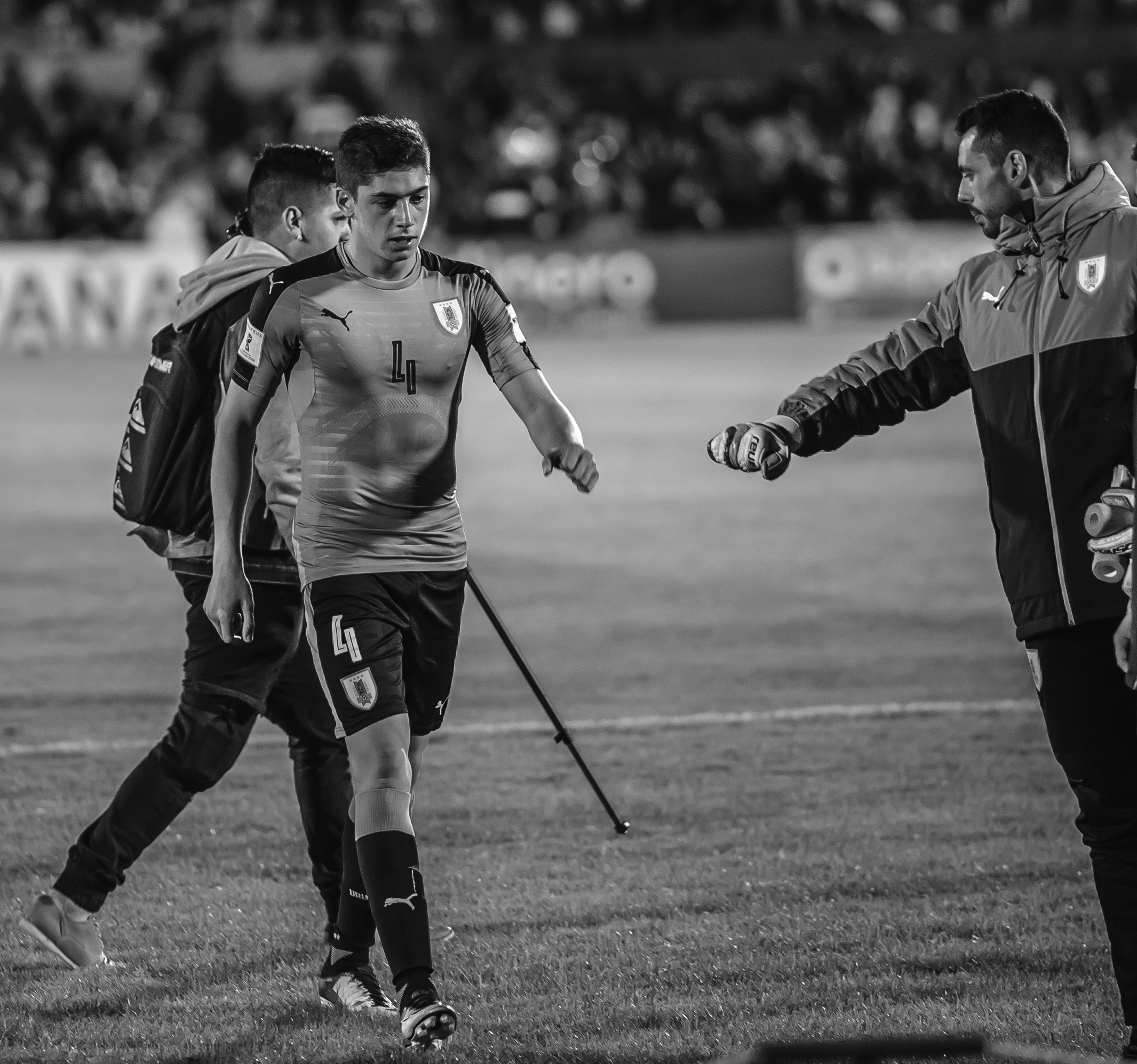 Federico Valverde w stroju Urugwaju na boisku, wspierany przez sztab.